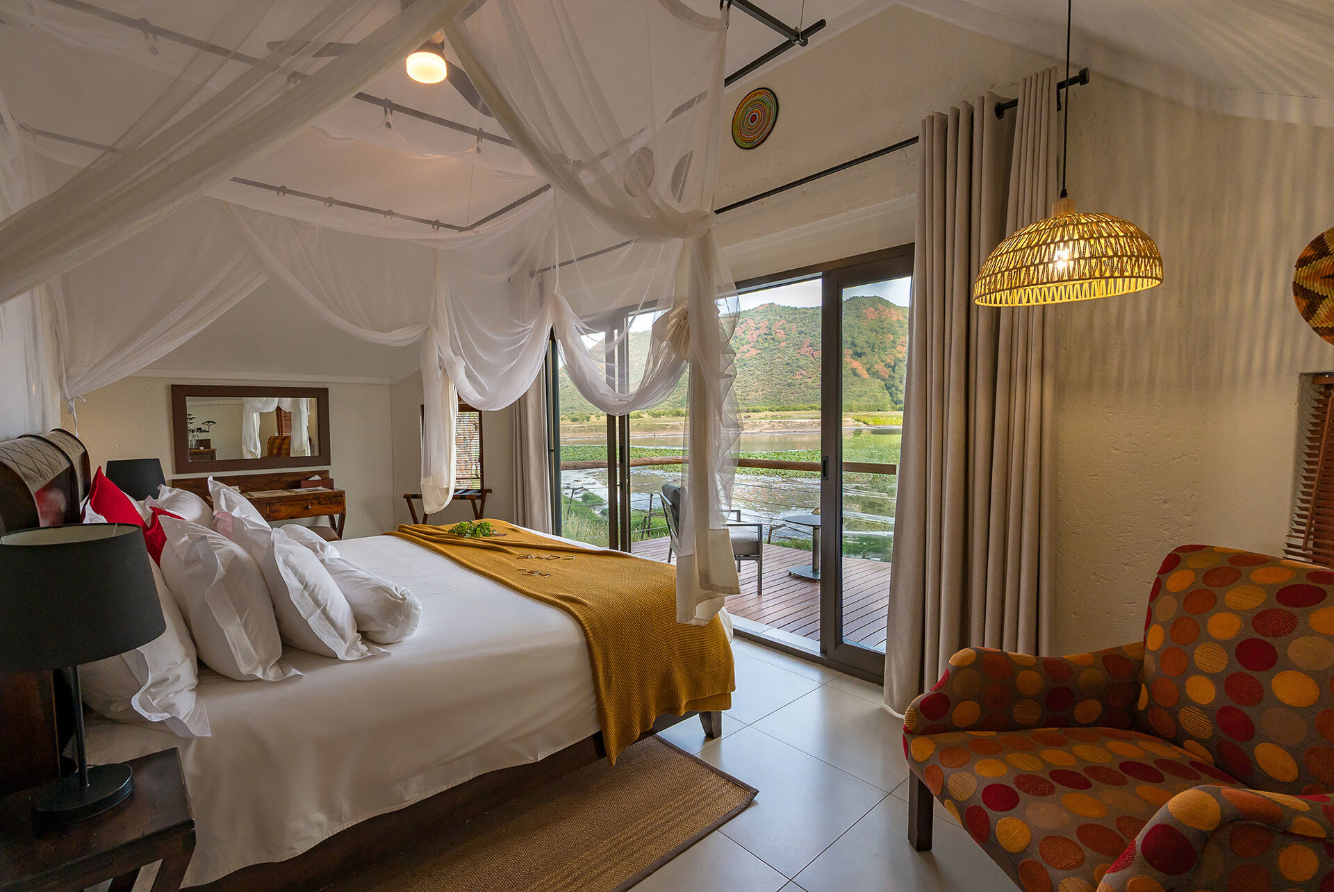 Tau Game Lodge thatched chalets around the waterhole in Madikwe