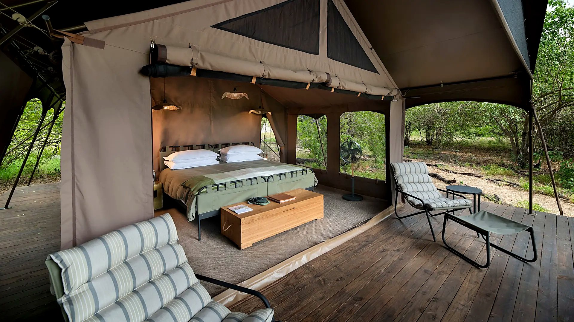 A luxury tented suite with a private deck and plunge pool overlooking the Okavango Delta at dusk