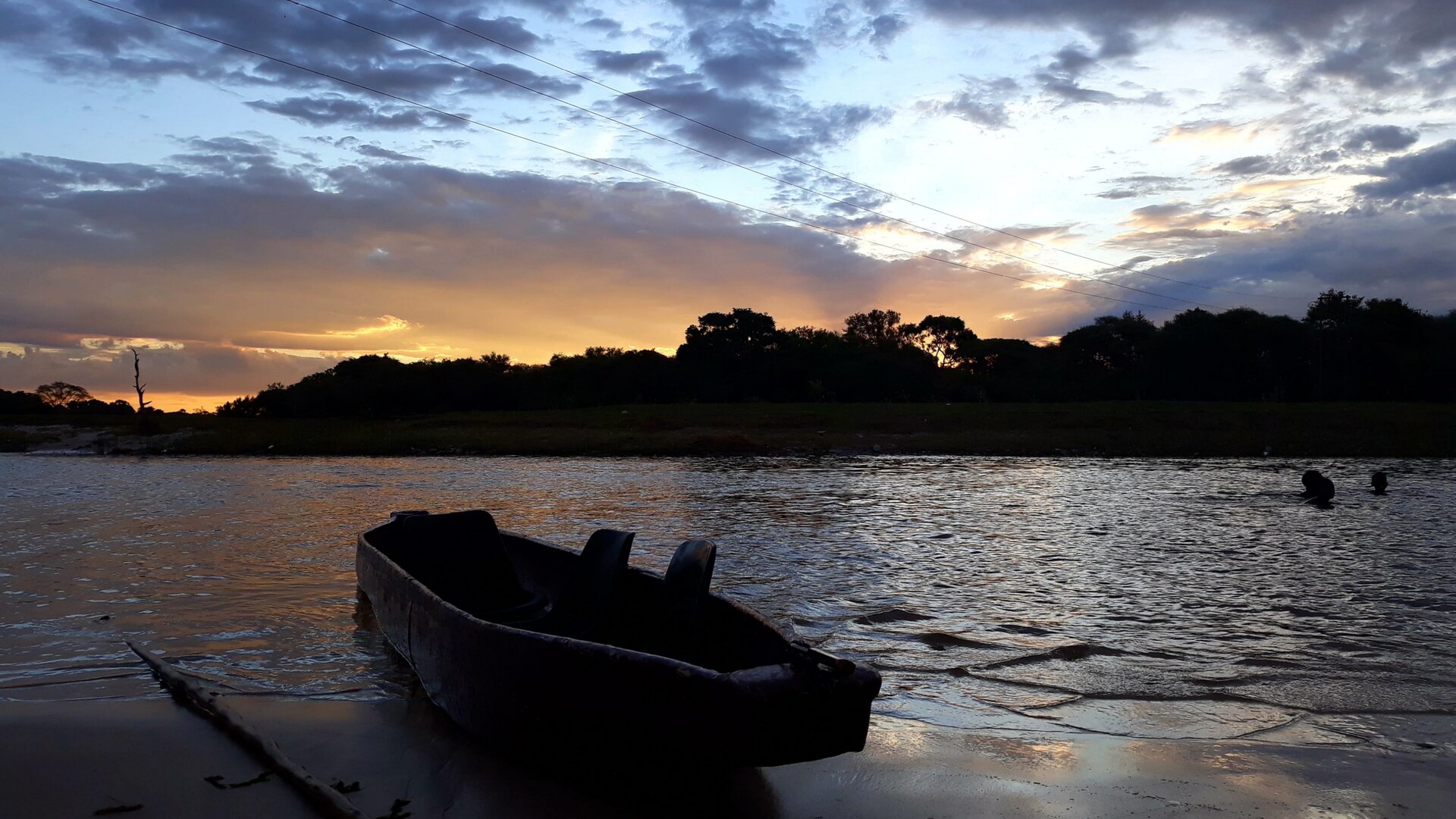 Mokoro canoe gliding through papyrus channels in the Okavango Delta at golden hour