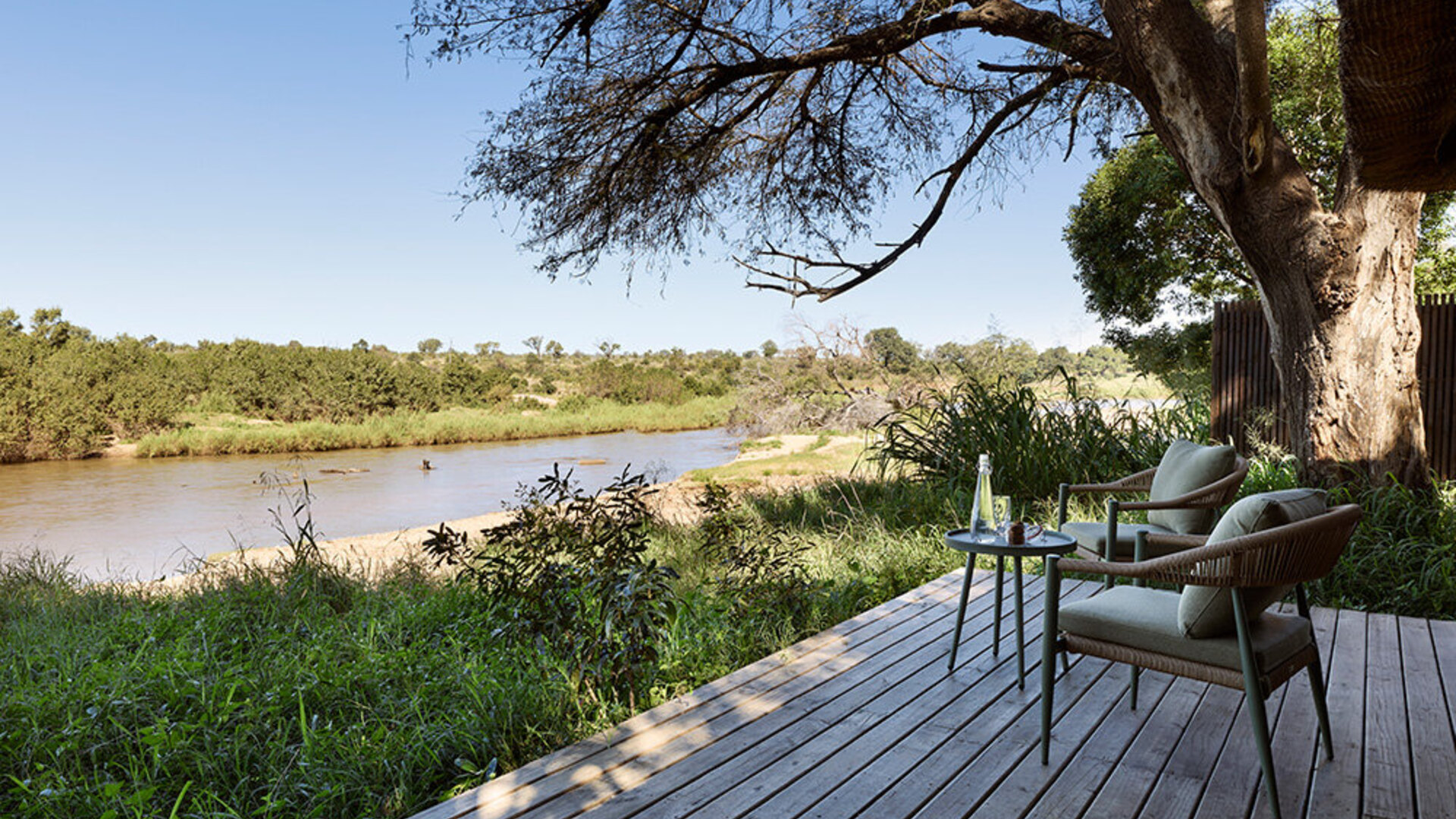 A river-view deck at an affordable-luxury safari lodge in South Africa at golden hour