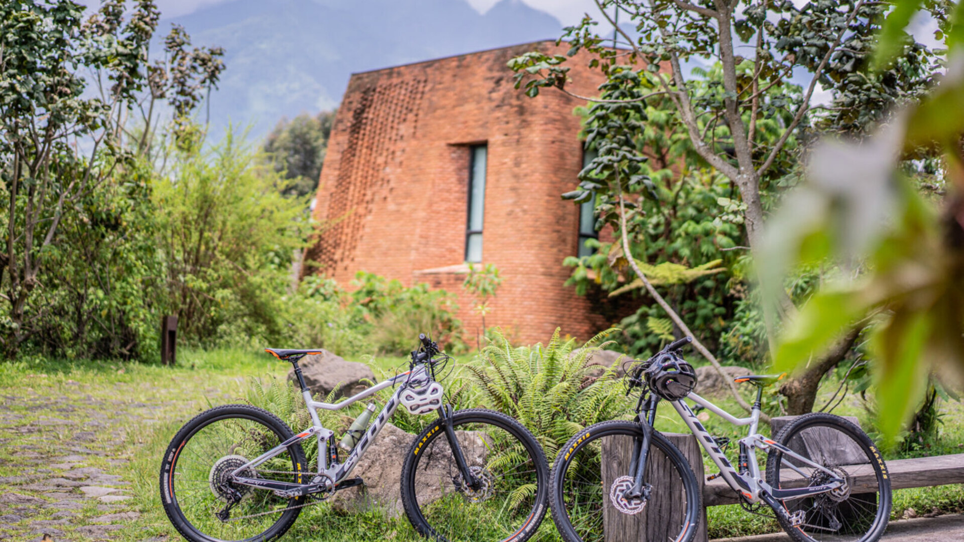 Luxury gorilla lodge with volcano backdrop in the Volcanoes National Park region of Rwanda at golden hour