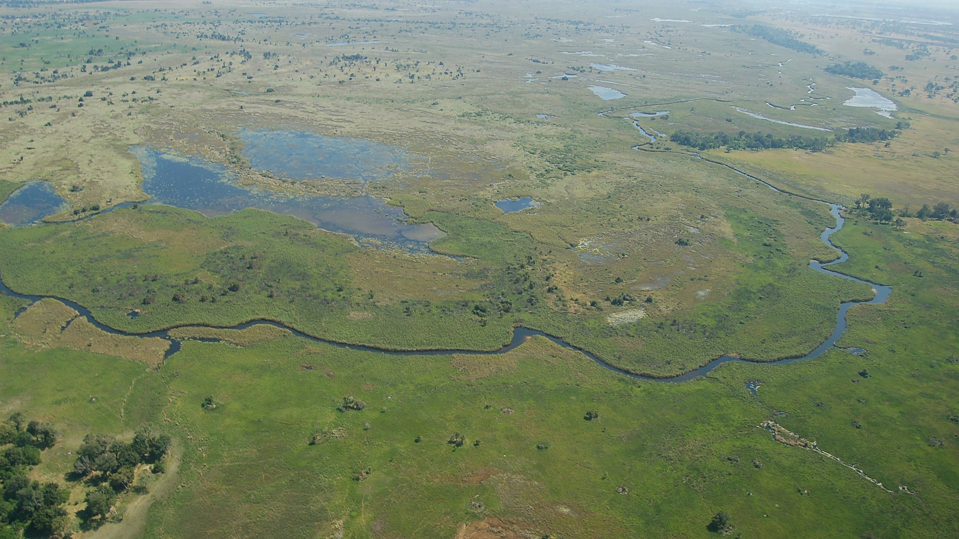 A luxury tented safari camp overlooking a floodplain in the Okavango Delta at golden hour