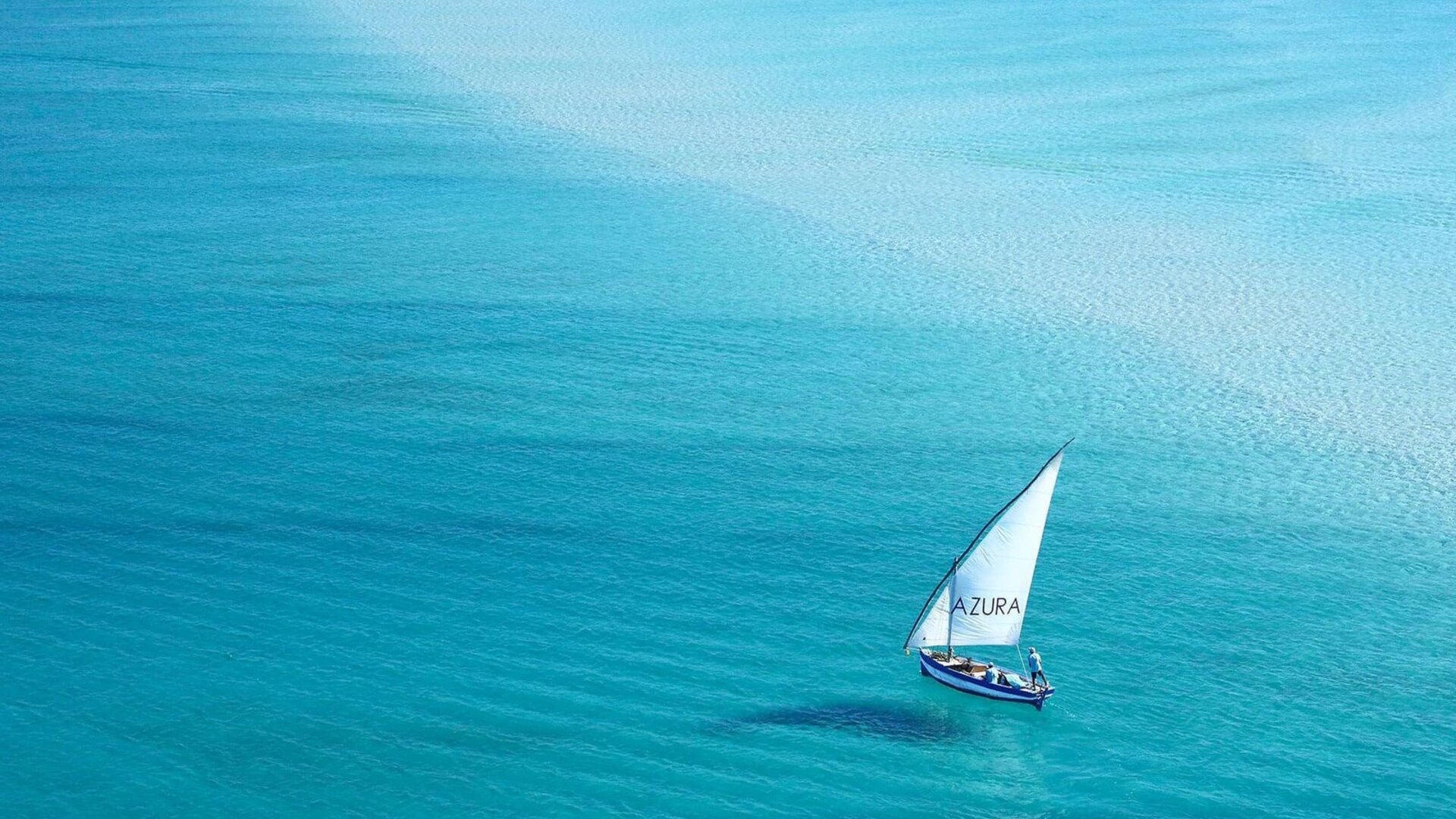 A traditional dhow sailing on turquoise water off Mozambique — the dry season, April to November, is the best time to visit Mozambique