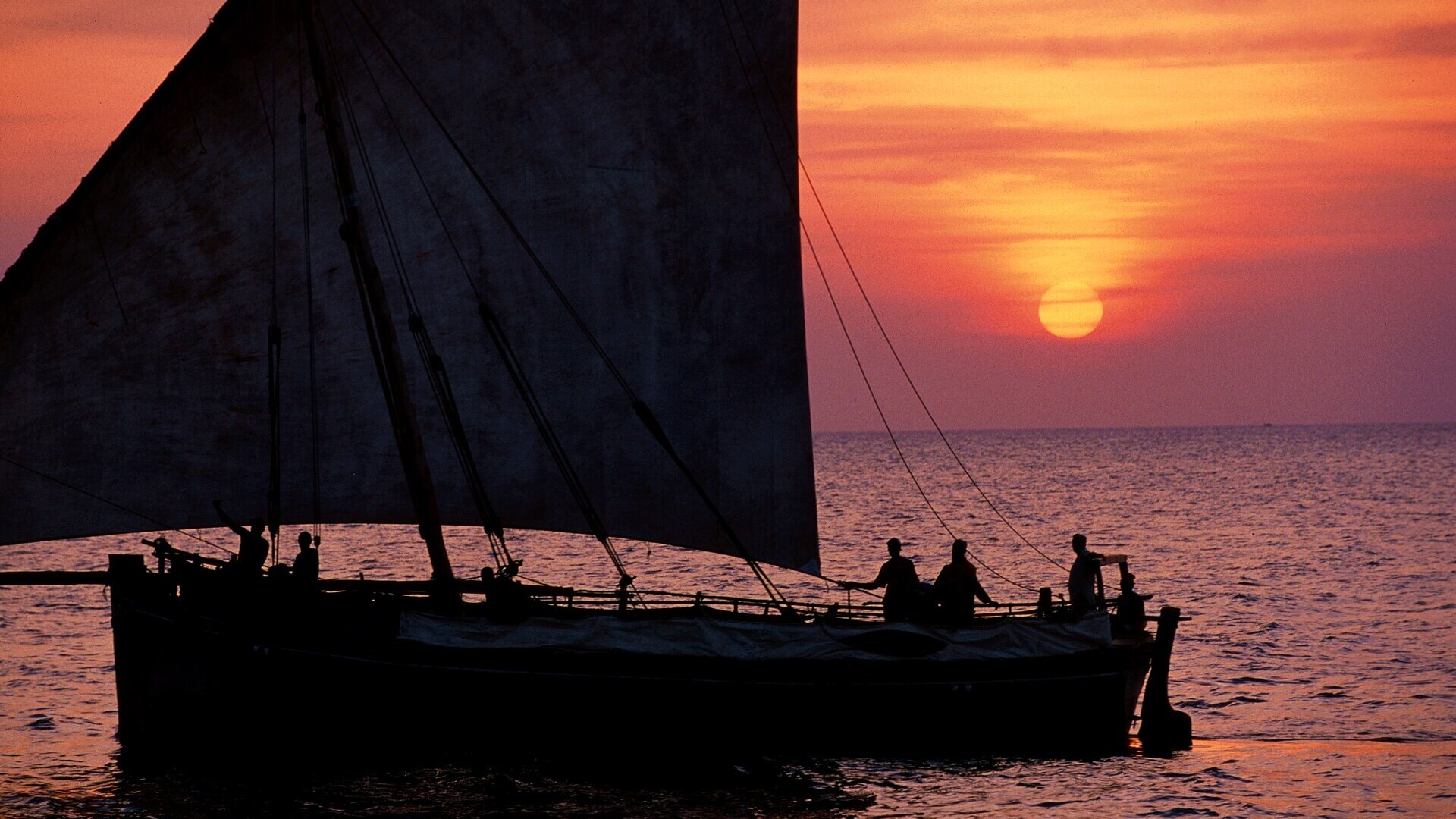 A traditional dhow sailing at sunset off Zanzibar — the dry season, June to October, is the best time to visit the spice island