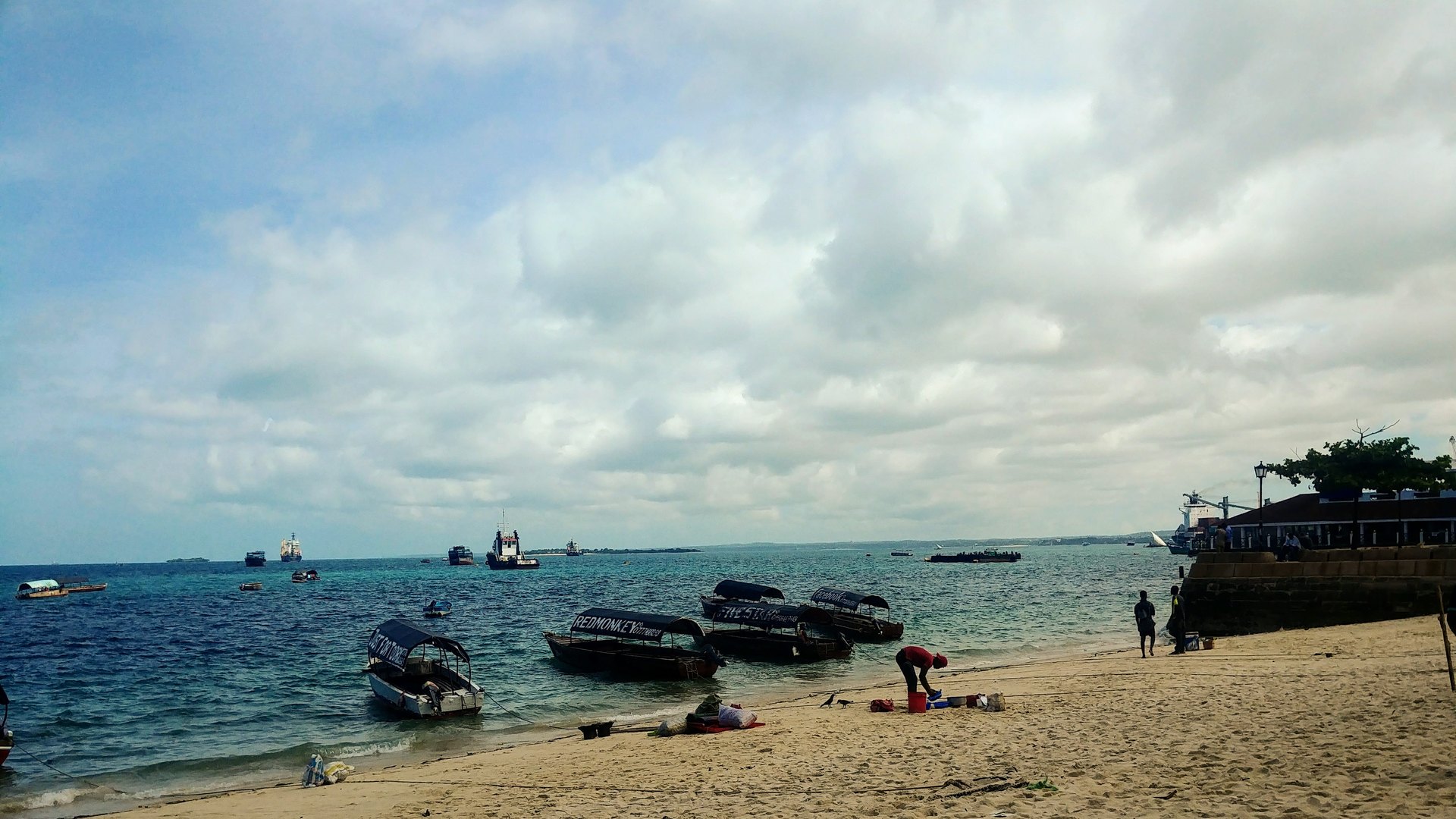 A white-sand tropical beach with dhows on the turquoise Indian Ocean in Zanzibar