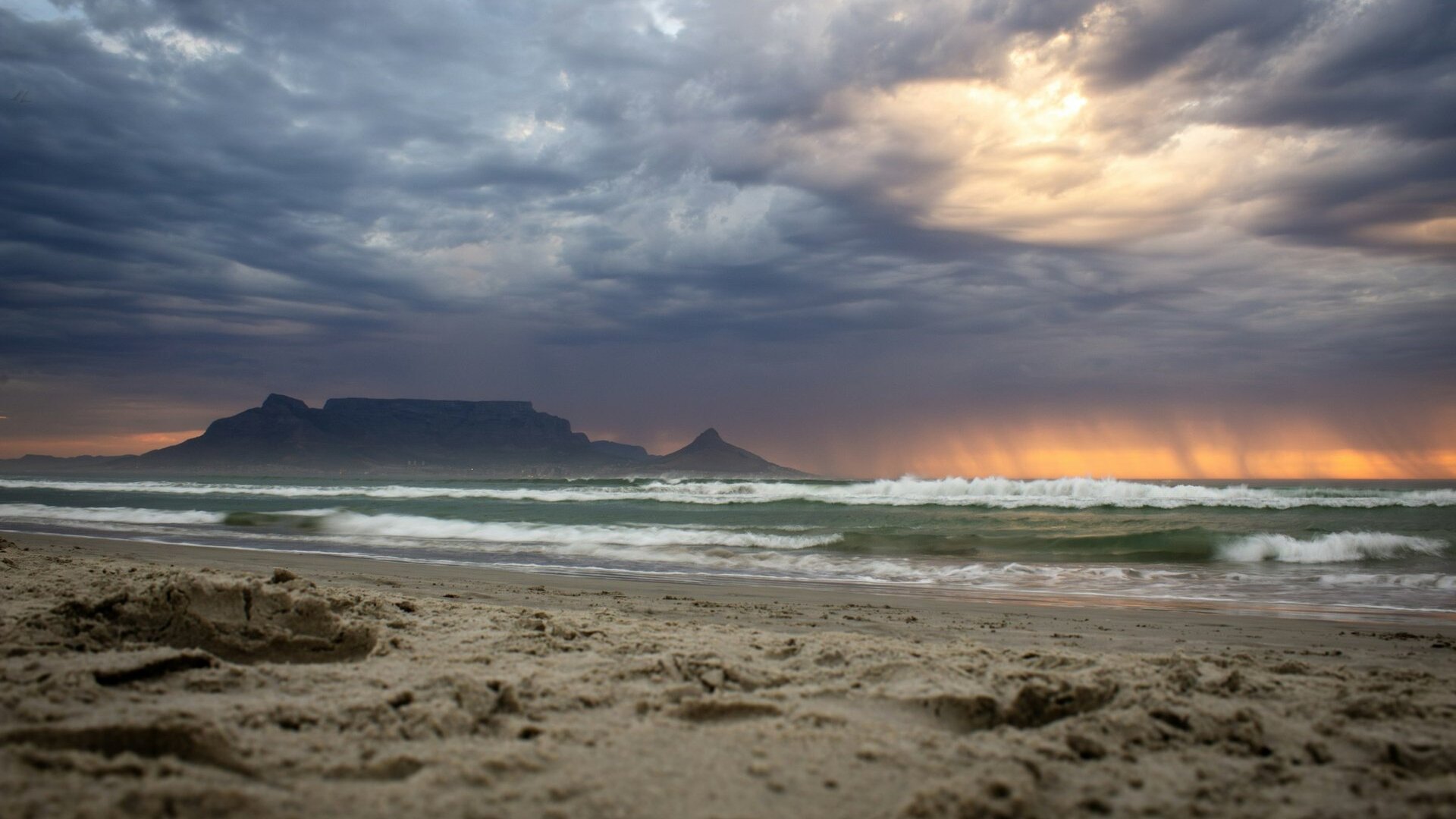 Table Mountain glowing at sunset above Cape Town with the city and ocean below