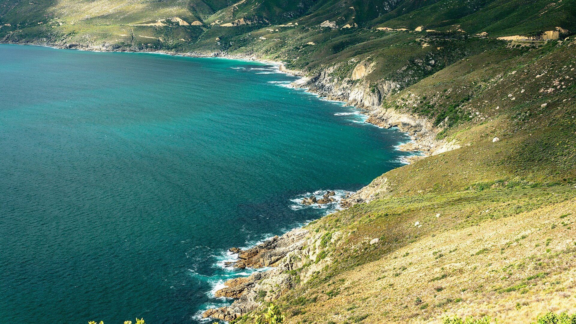 A luxury vehicle descending Chapman's Peak Drive with the Atlantic Ocean stretching to the horizon — the quintessential Cape Town private driver experience