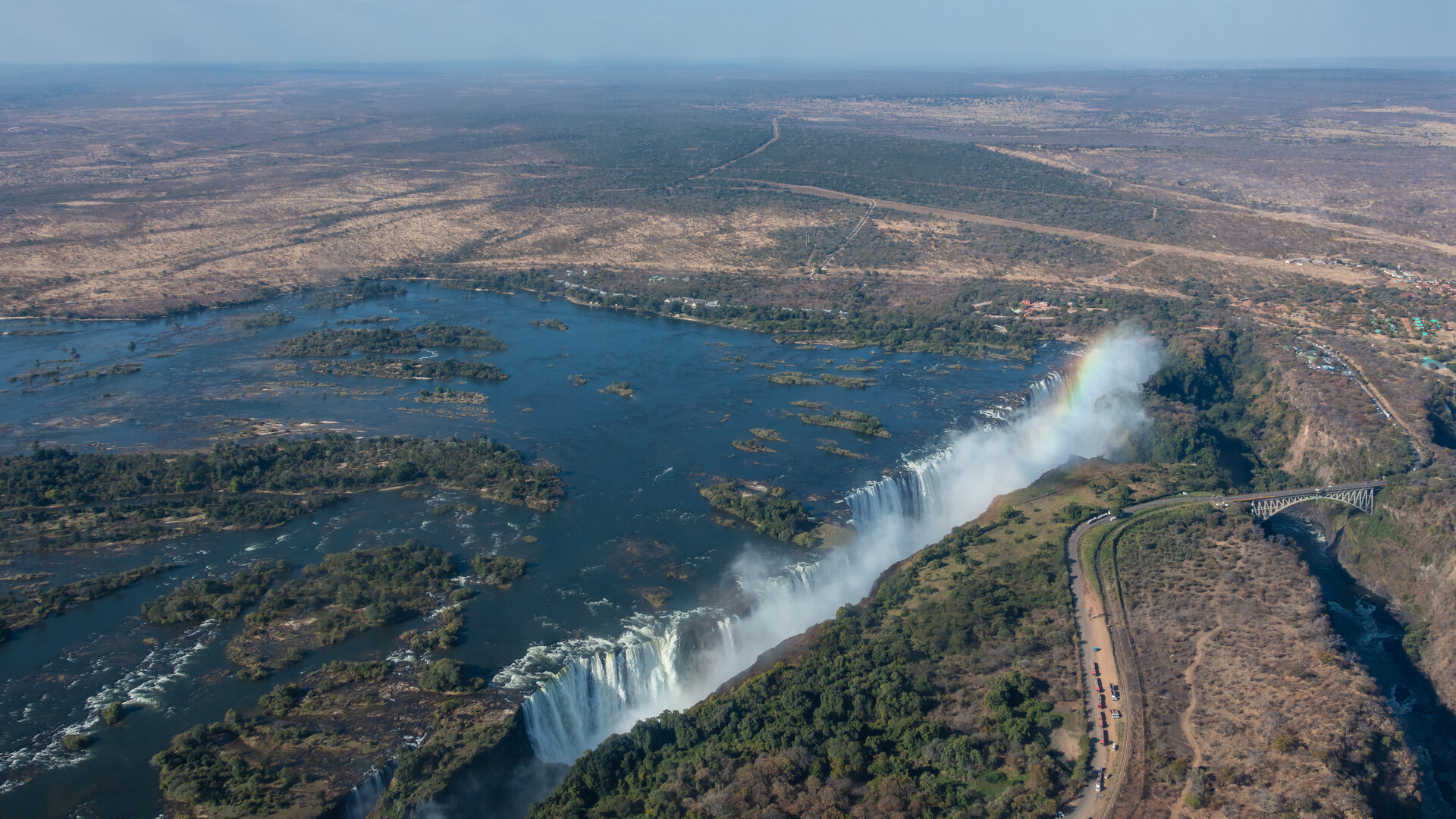 Aerial view of Victoria Falls thundering into the gorge with a rainbow over the spray