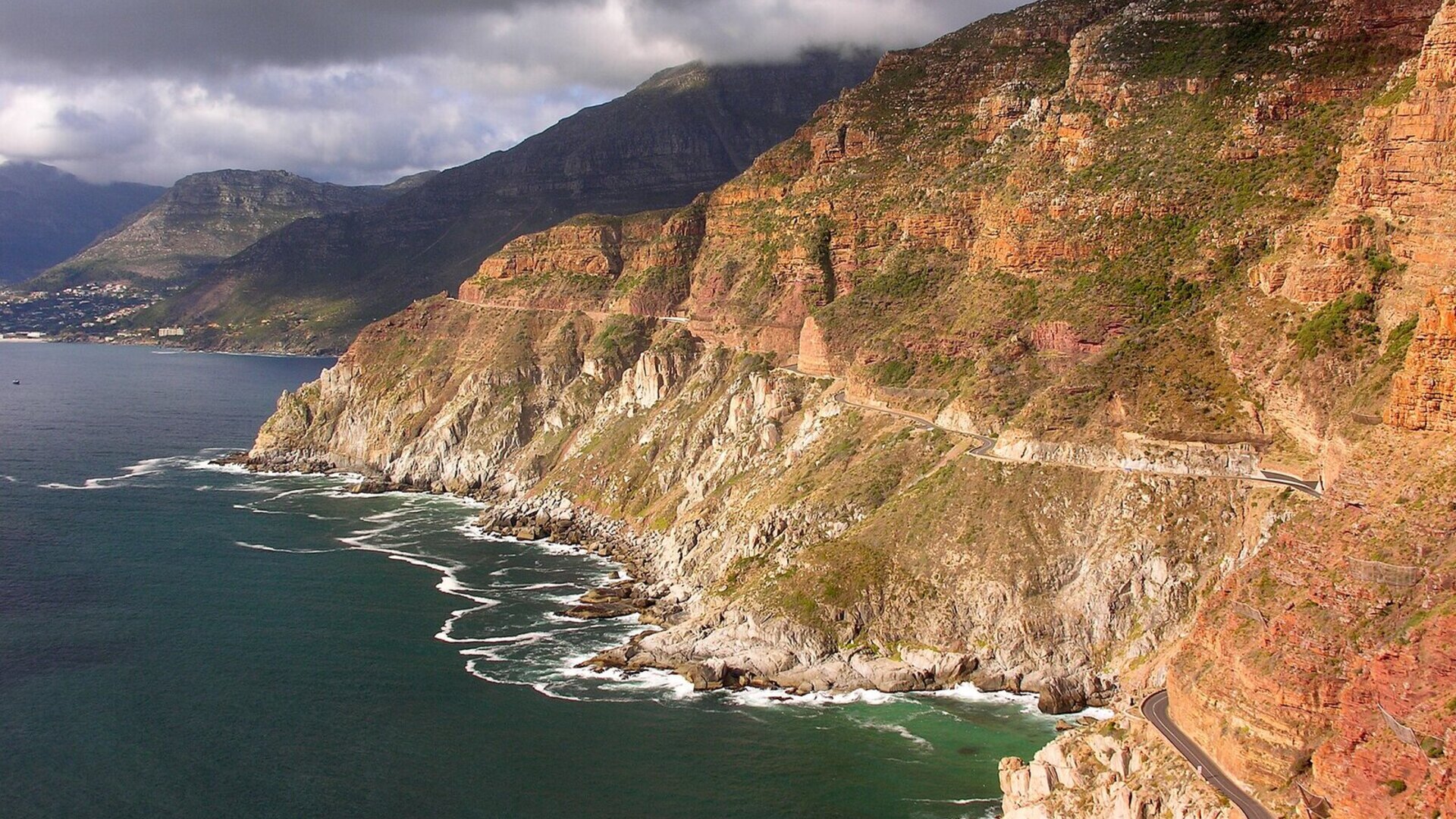 A helicopter soaring over Cape Town coastline and Table Mountain toward the vineyards of the winelands at golden hour
