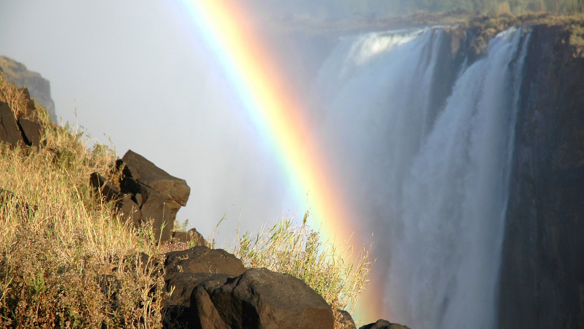 Aerial view of Victoria Falls with rainbow and rising spray on a honeymoon safari