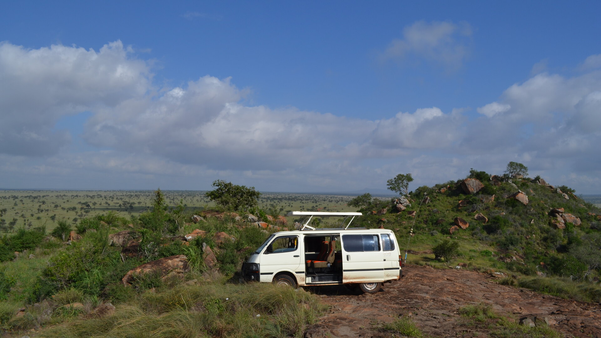 A safari vehicle with guests pausing in the open Kruger bushveld