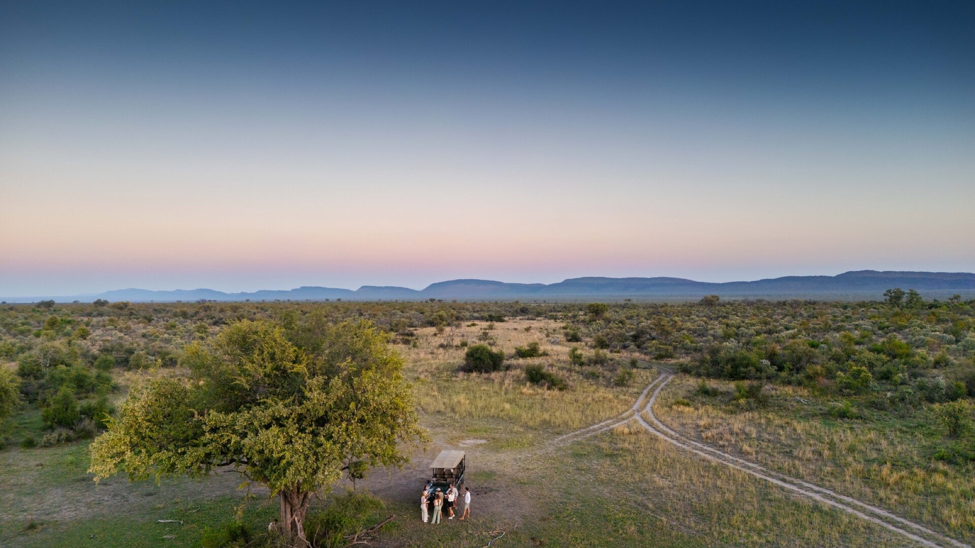 The main lodge and infinity pool at Jaci's Lodges overlooking the Madikwe bushveld at golden hour
