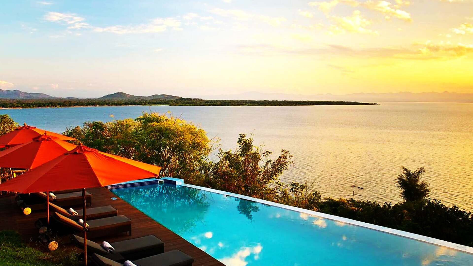 An infinity pool overlooking Lake Malawi at golden hour