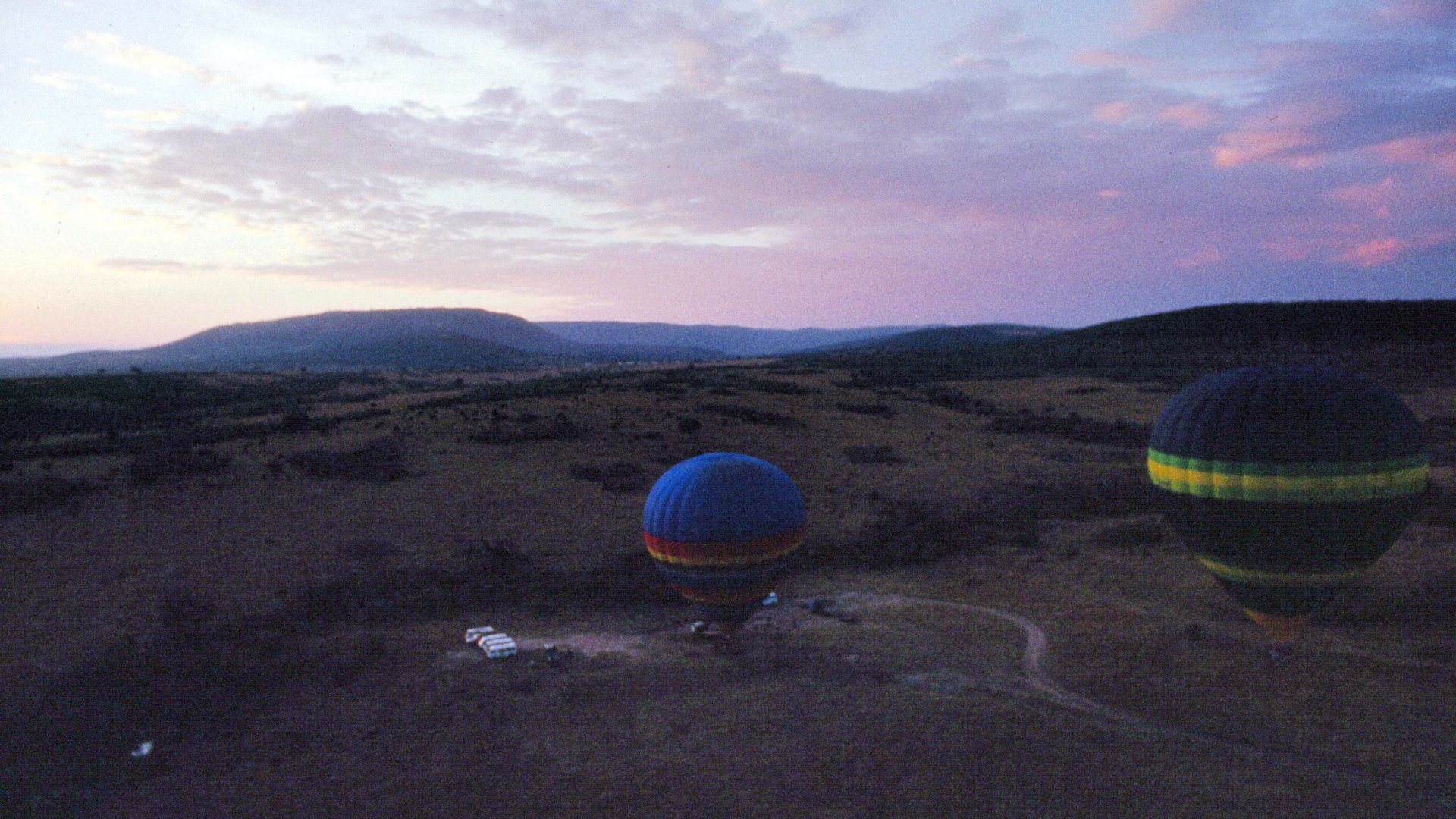 Hot air balloons drifting over the Masai Mara plains at dawn, a highlight of a family safari