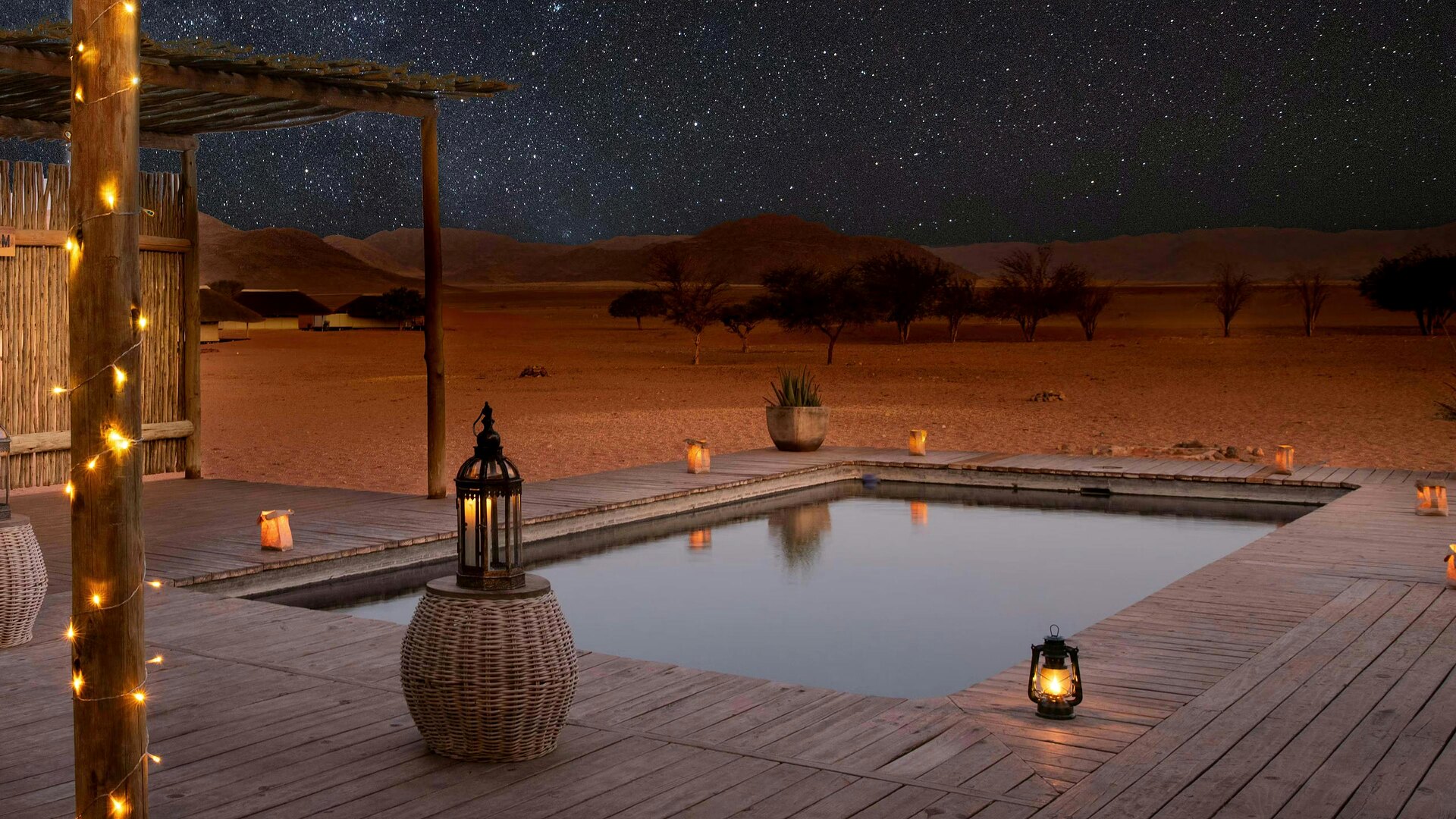 Romantic couple at a luxury desert lodge with private deck overlooking the dunes at sunset
