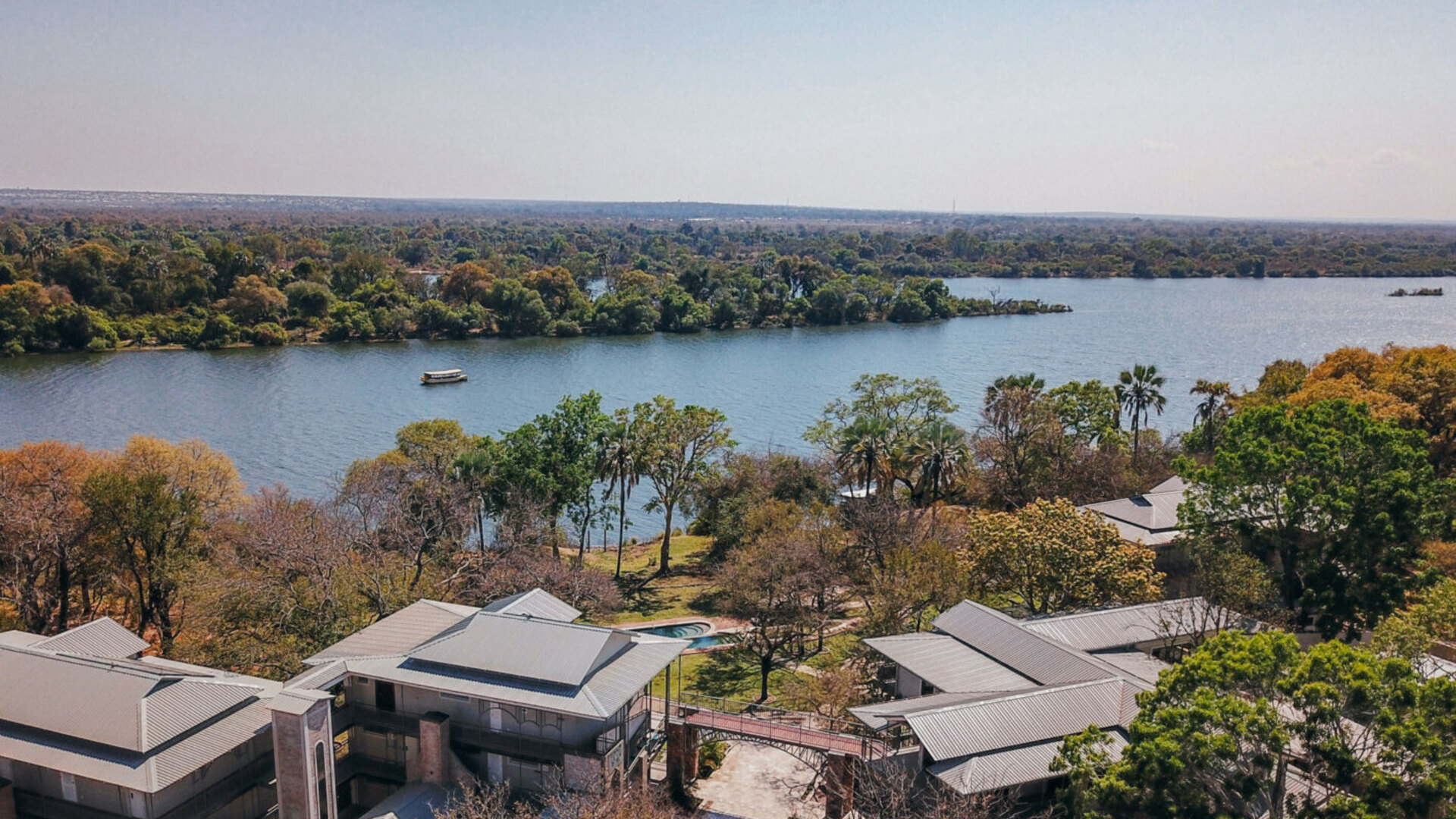 Aerial view of The Palm River Hotel on the banks of the Zambezi River above Victoria Falls at golden hour