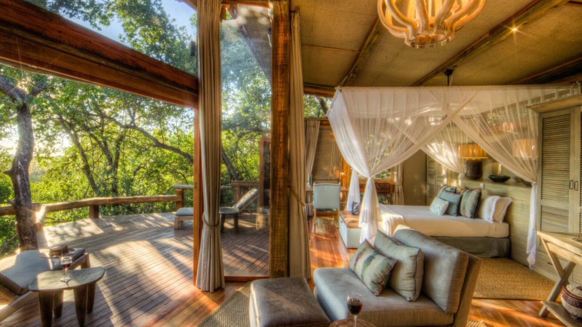 A luxury tented safari suite opening onto a private deck over a green canopy — safari lodges with no single supplement for solo travellers