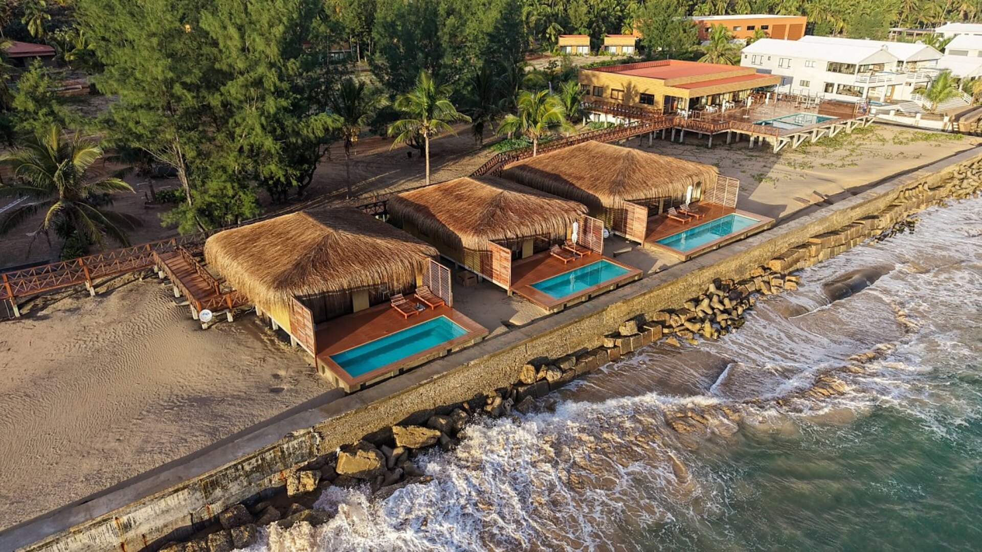 Aerial view of Sentidos Beach Retreat on Praia da Barra, Inhambane — thatched villa suites with private pools above the Indian Ocean, Mozambique's whale shark and manta capital