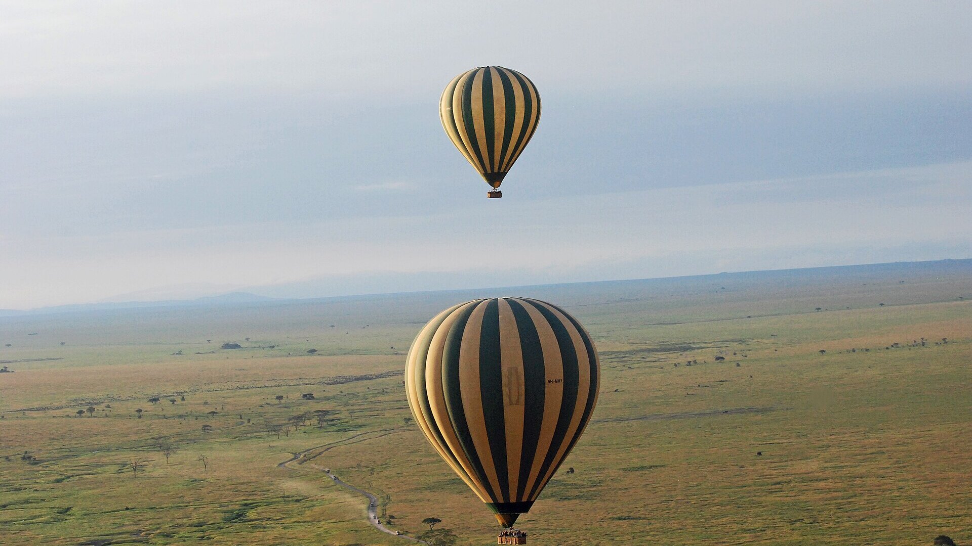 Romantic glass-fronted honeymoon suite overlooking the Masai Mara at sunset — top luxury honeymoon safari destinations in Africa 2026