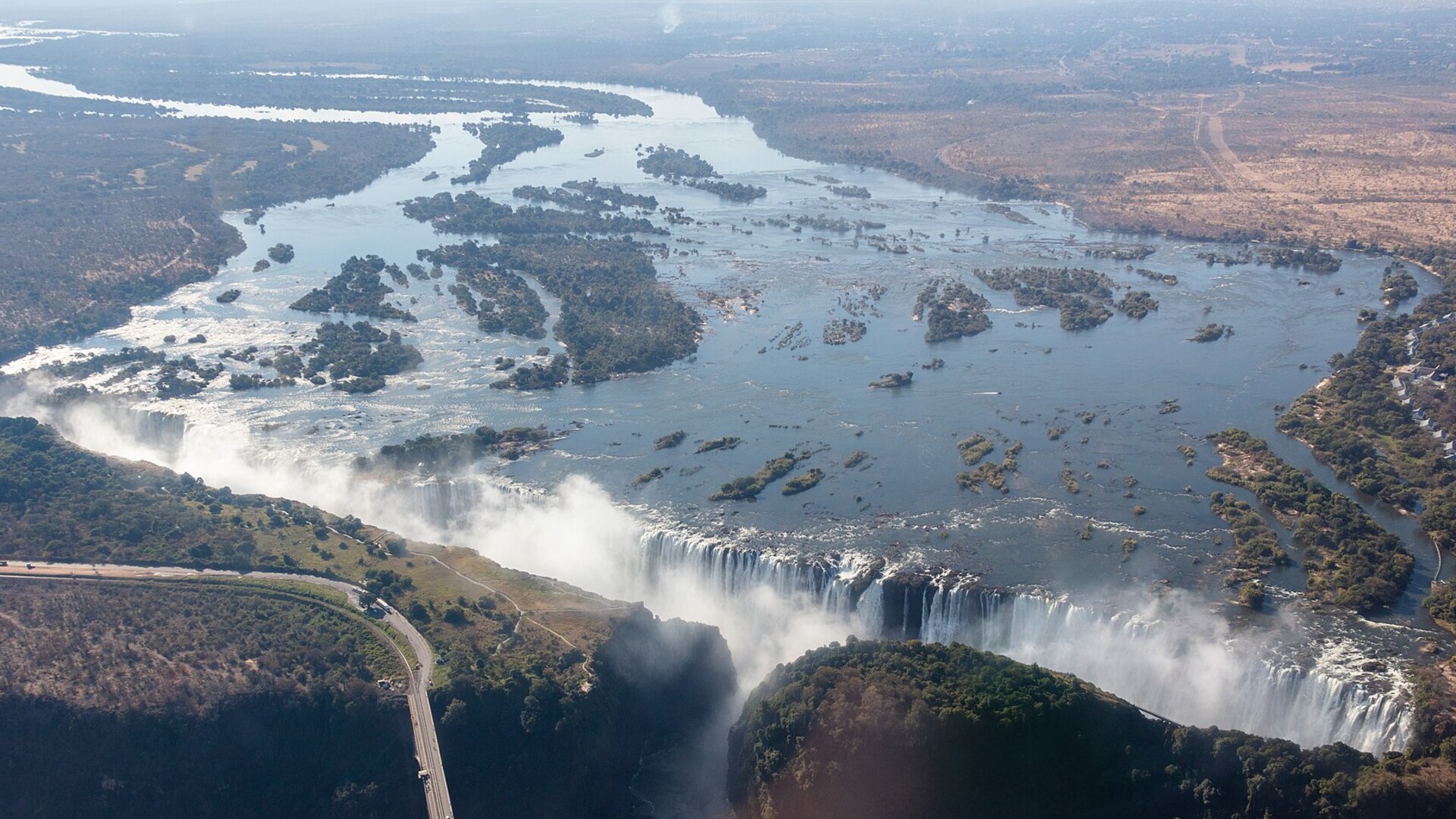 Victoria Falls spray and rainbow rising above the Zambezi gorge — the backdrop for Africa's finest luxury lodges