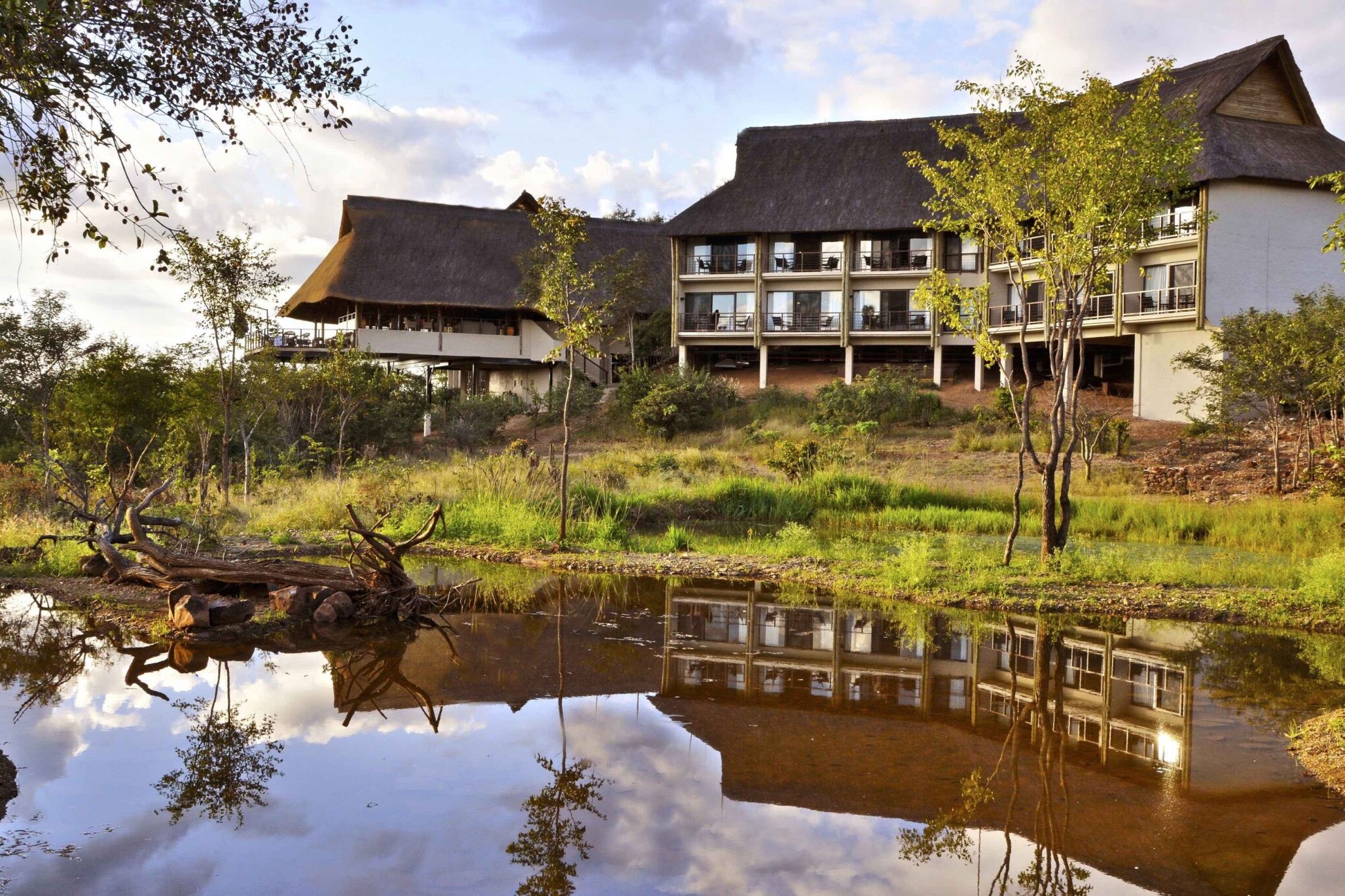 Victoria Falls Safari Club reflected in the estate waterhole at dusk