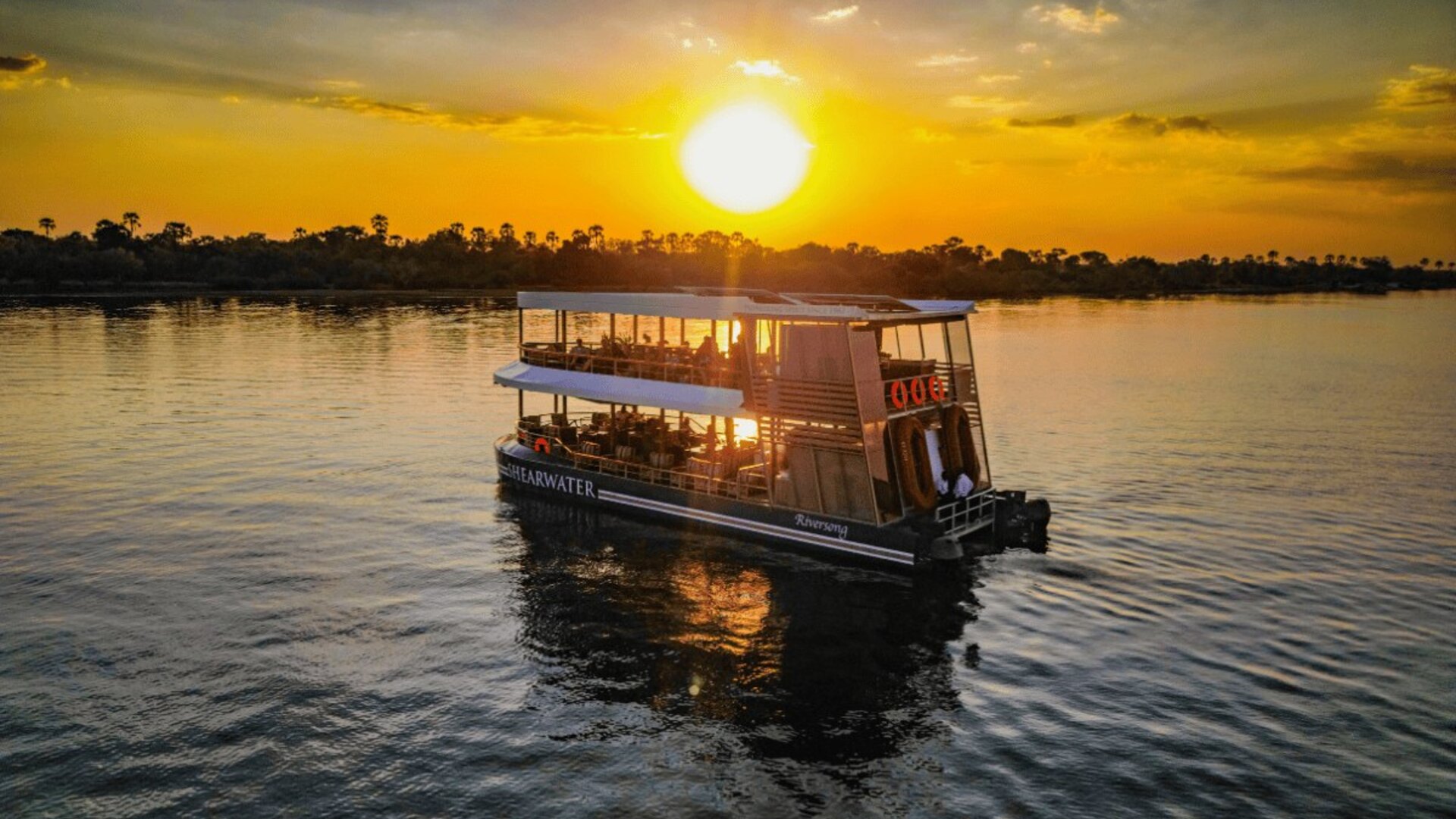 A sunset boat cruise on the Zambezi River with the sky turning gold
