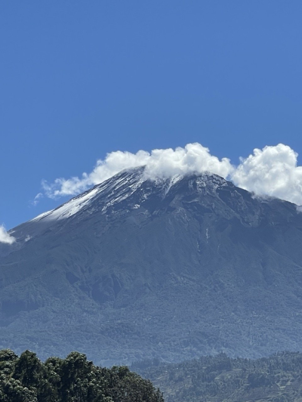Mount Meru's snow-dusted volcanic summit rising above Arusha National Park