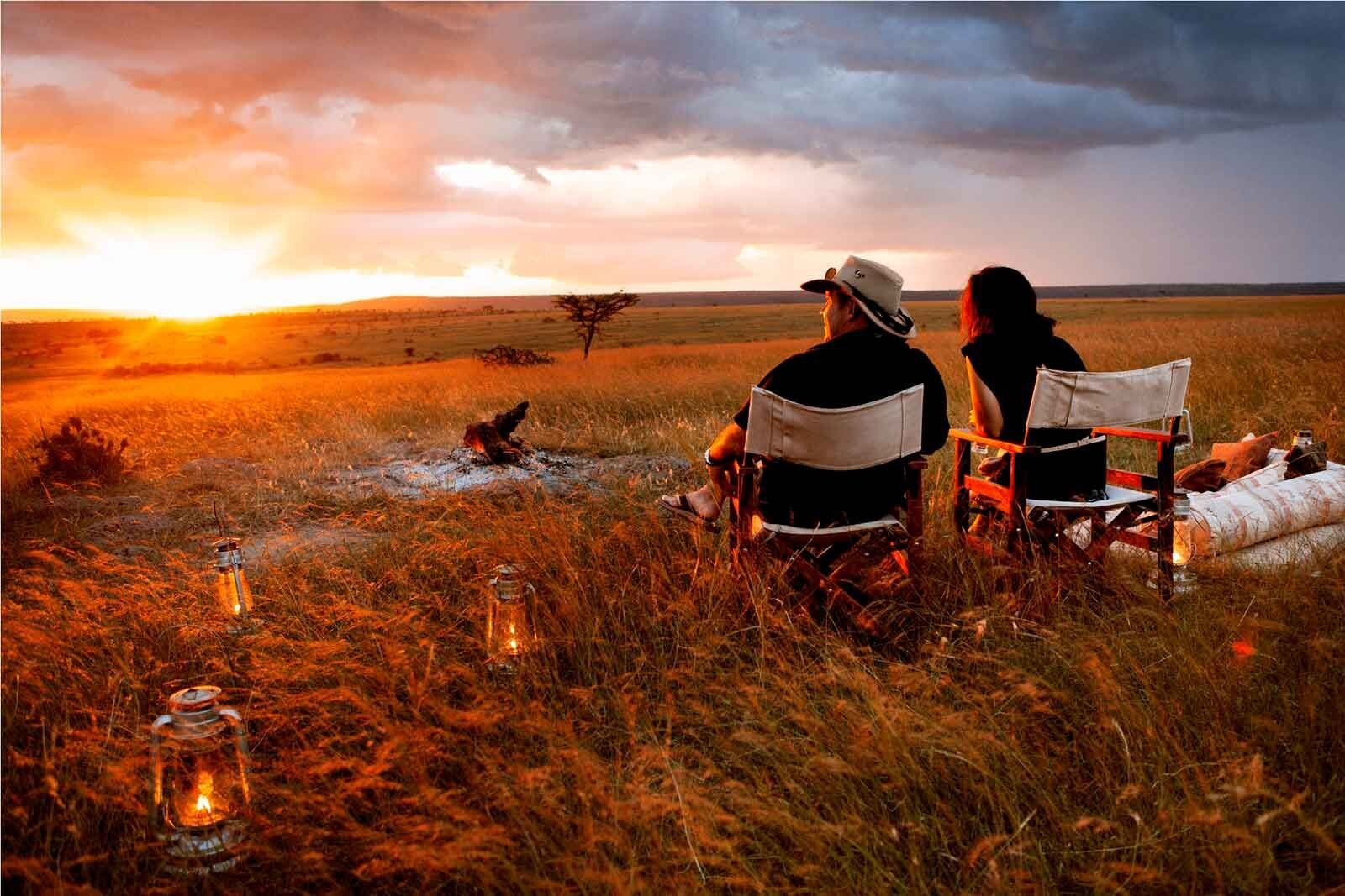 Newlywed couple watching elephants at sunset from a private safari lodge deck in Africa