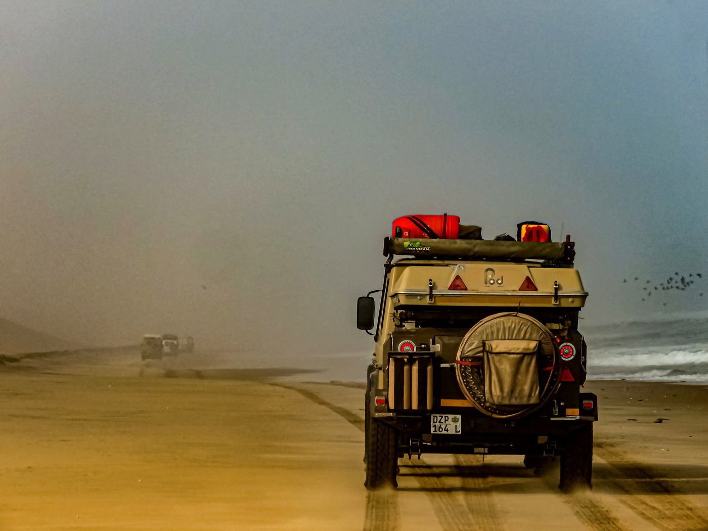 Safari vehicles on Angola desert plains
