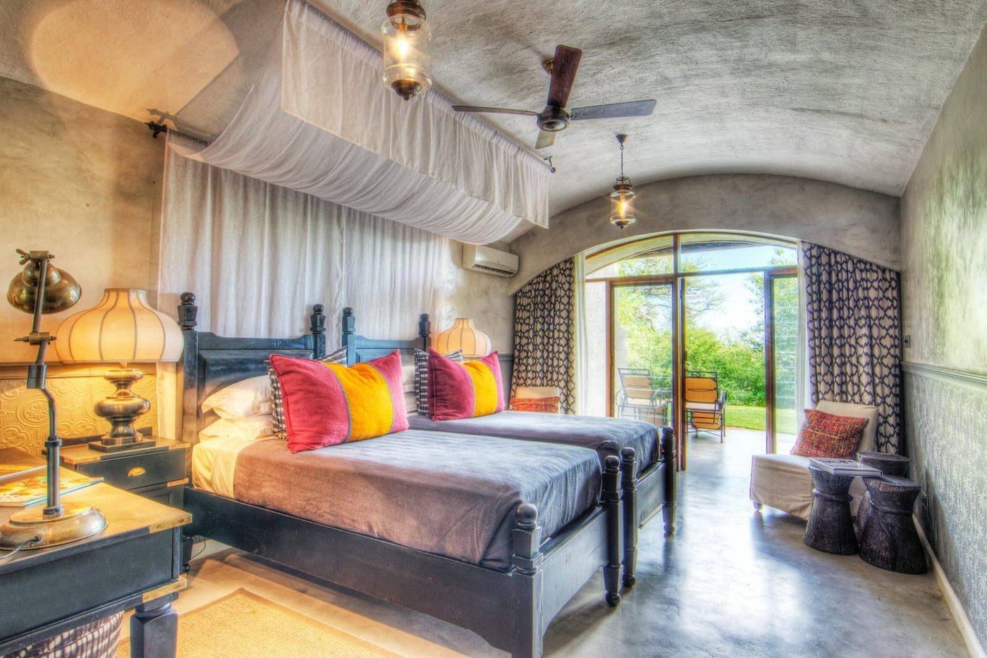Chobe Game Lodge riverfront suite with four-poster bed, vaulted ceiling and doors opening onto the Chobe River