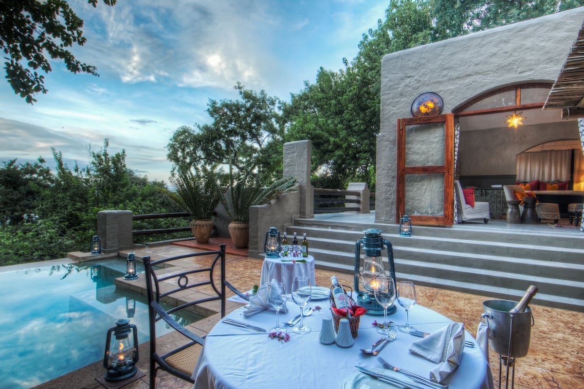 A candlelit private dinner set beside the pool at Chobe Game Lodge overlooking the Chobe River