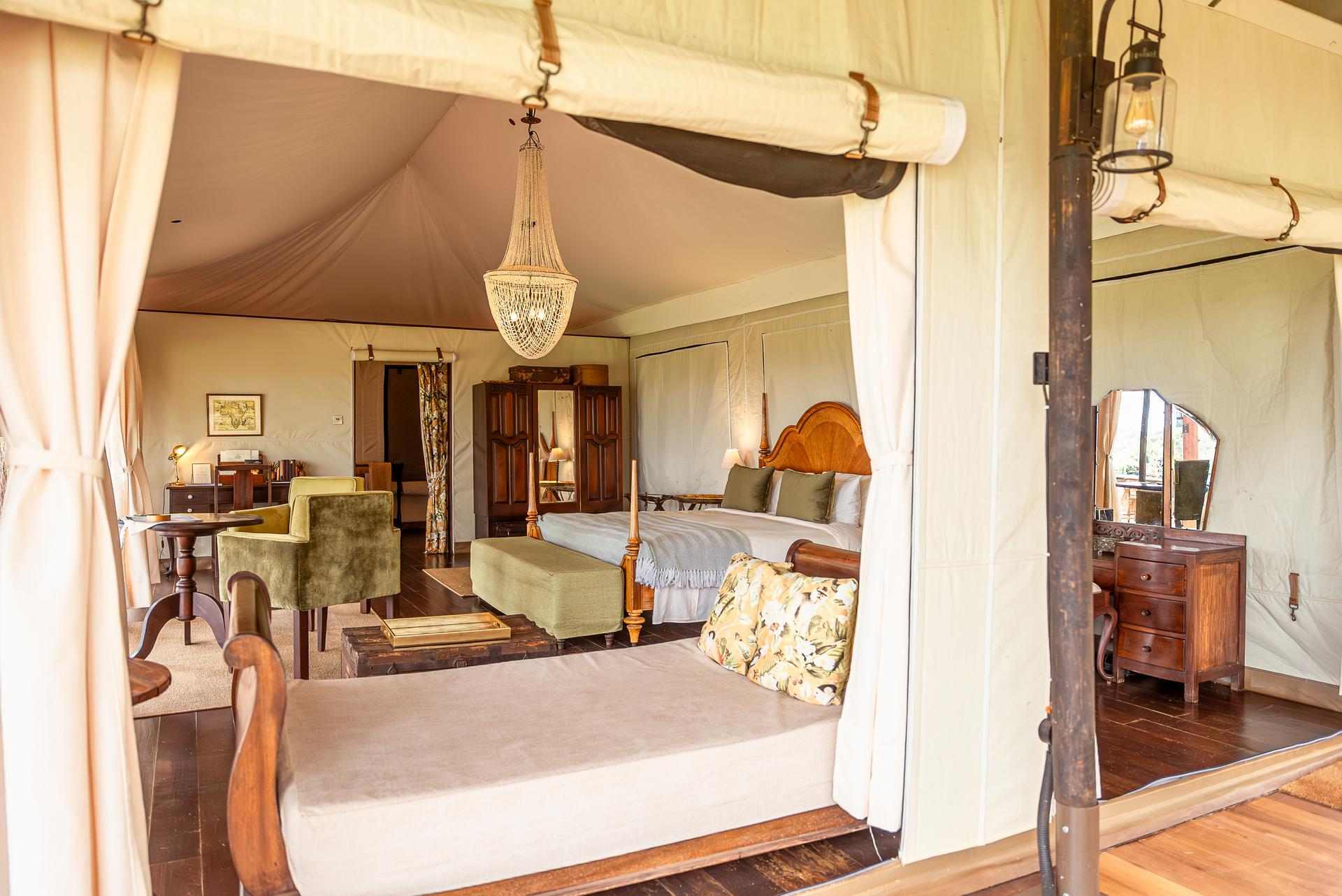 A vintage canvas tent interior — four-poster bed, campaign furniture, 1920s safari romance.