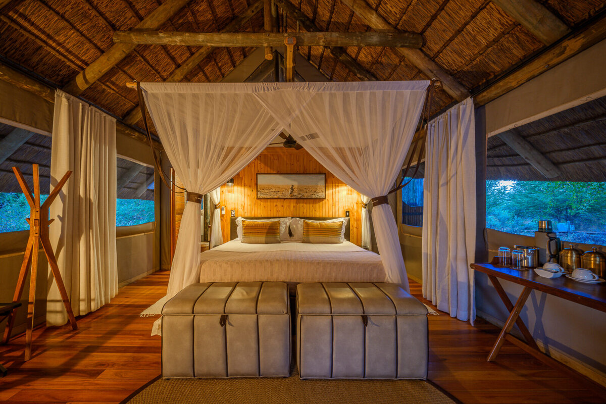 Dinaka guest suite interior &mdash; canvas-and-thatch comfort in the bush
