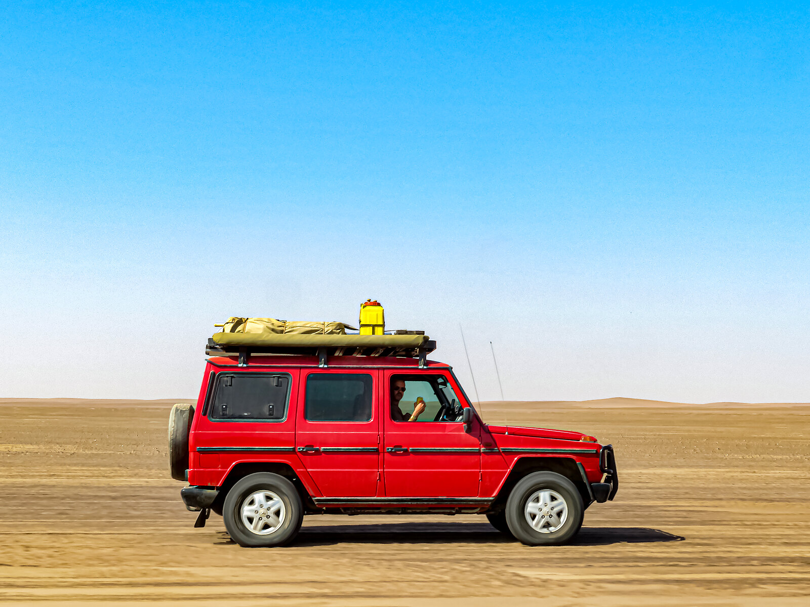 Overland vehicle on the desert flats of Iona National Park