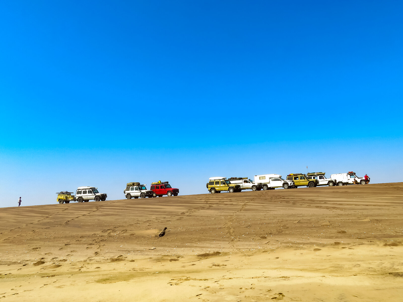Convoy of 4x4s on a dune ridge in Iona National Park