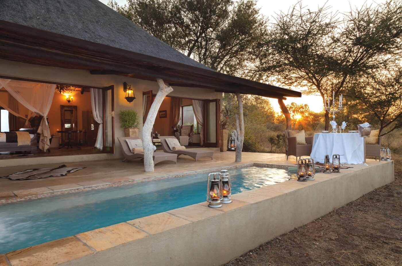 Private suite pool and deck at sunset with lanterns, Kings Camp, Timbavati