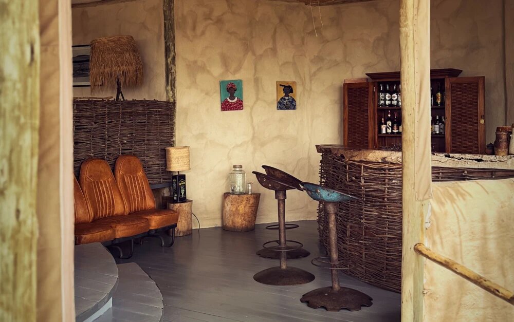 Characterful bar area at Lamai Serengeti with wicker chairs and local artwork
