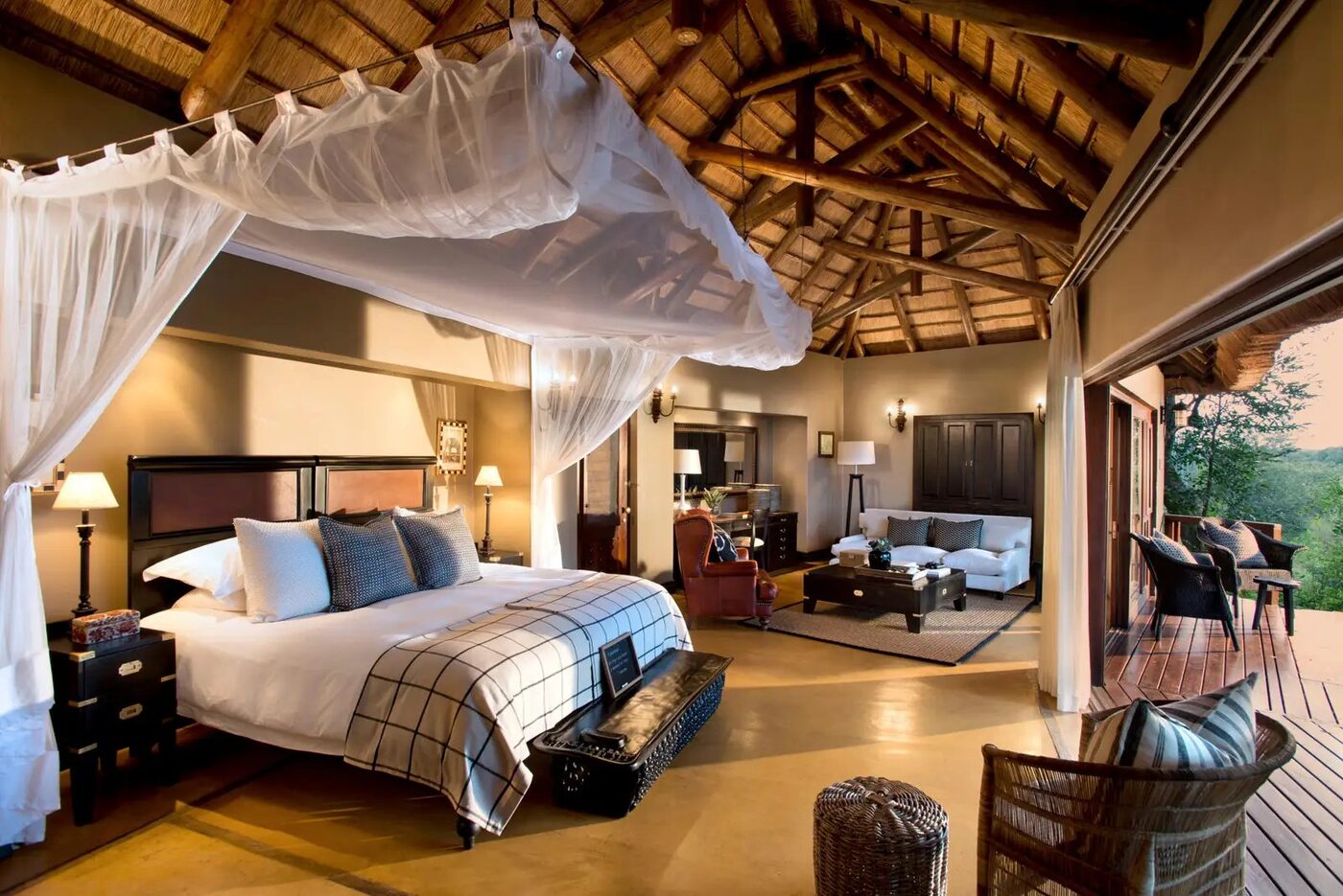 Luxury suite with four-poster bed and lounge at Lion Sands, Sabi Sand Game Reserve