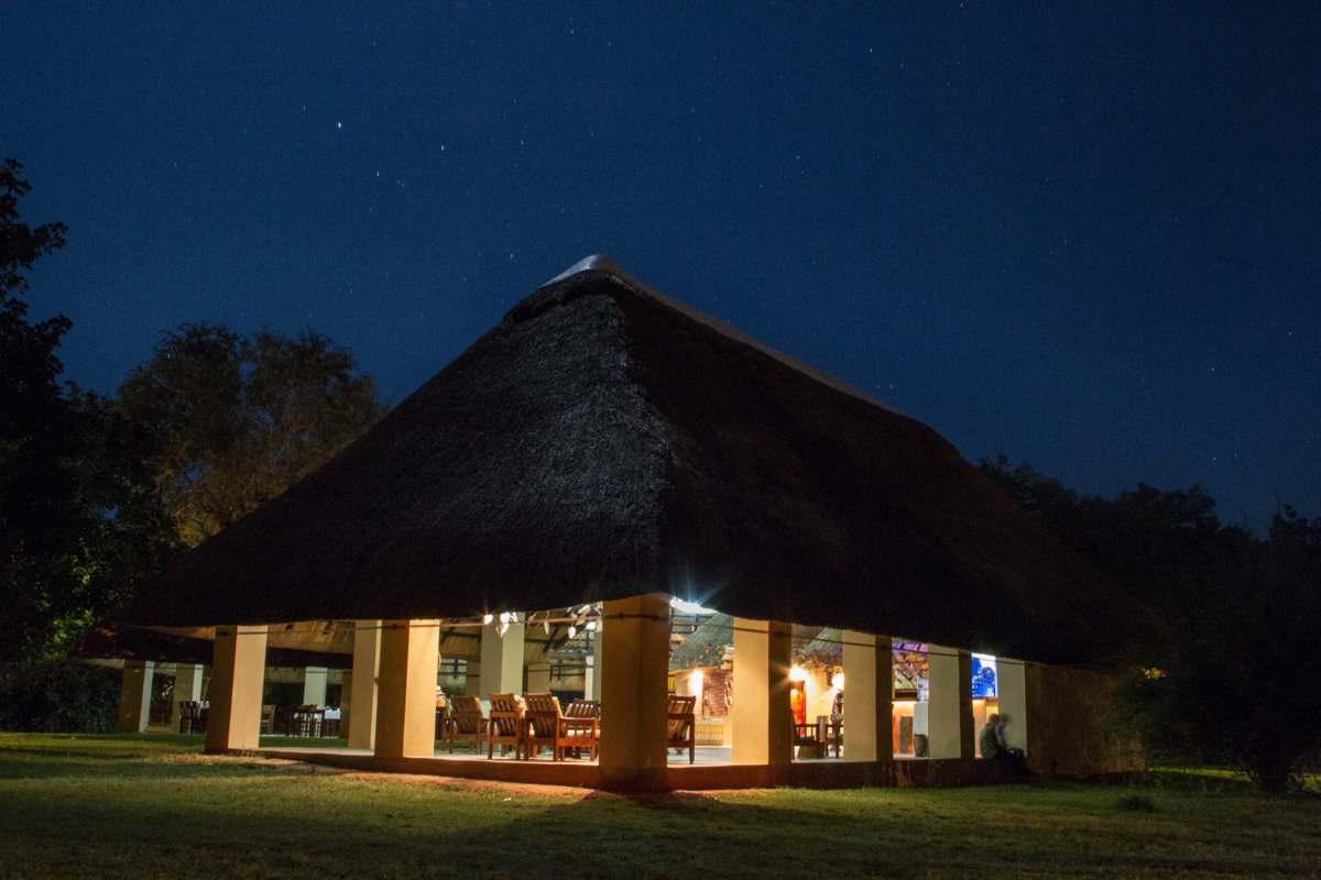 Marula Lodge thatched main area lit up at dusk, Timbavati