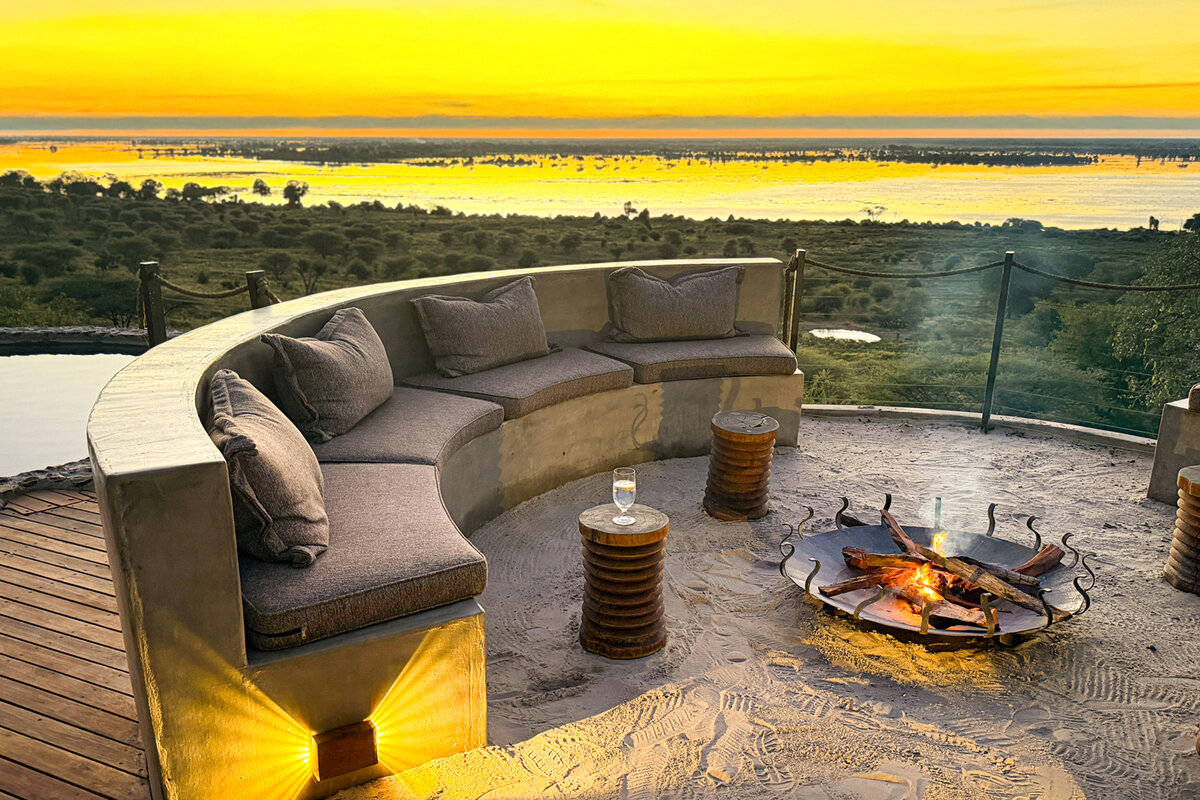 Ngoma Safari Lodge sunken firepit lounge on the deck overlooking the Chobe River floodplain at golden sunset