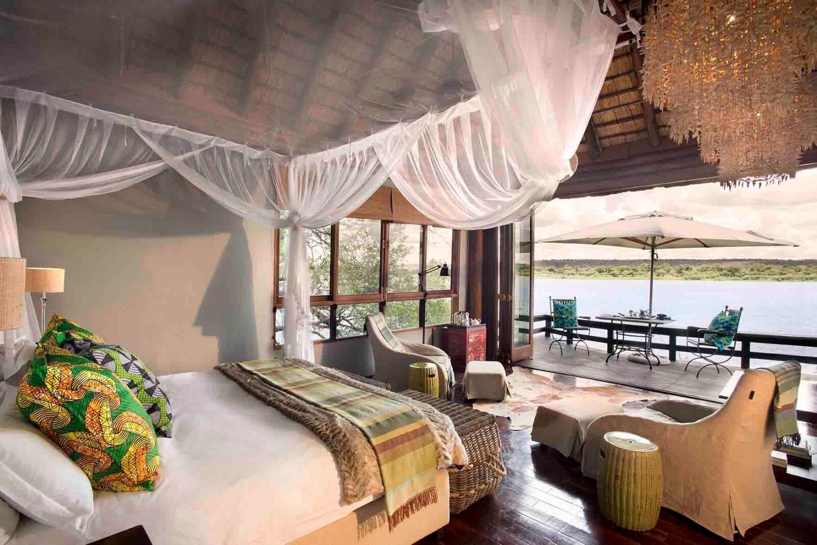 Royal Chundu luxury suite bedroom with four-poster net and Zambezi river view, Livingstone Zambia