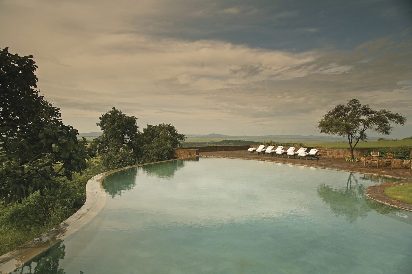 Singita Sasakwa Lodge hillside suite with glass frontage and plains view, Serengeti Tanzania
