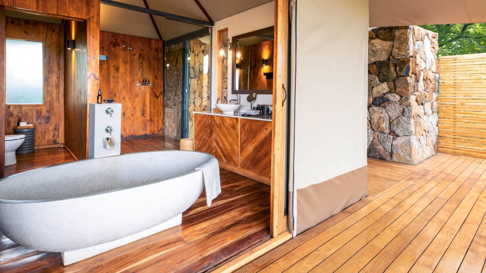 En-suite bathroom at Sayari Camp with a freestanding tub opening onto the deck