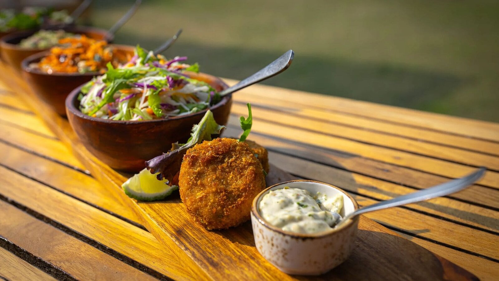 Signature plated dish served on a timber table at Sayari Camp