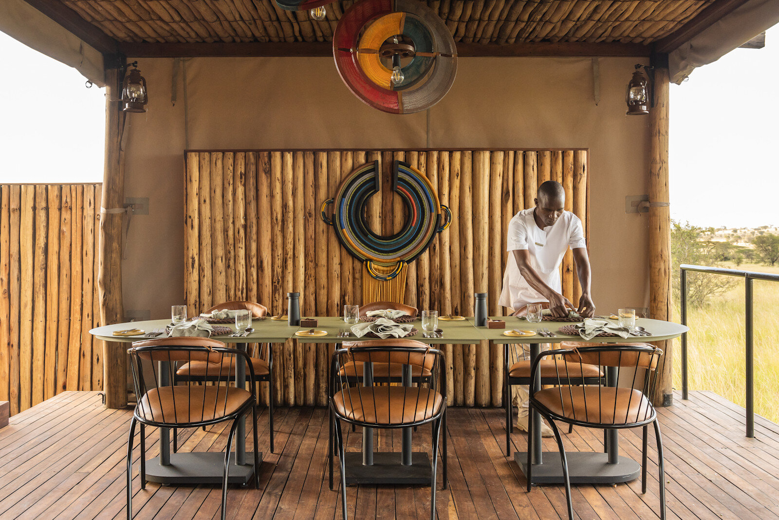 Deck dining table set for dinner service at Singita Mara River Tented Camp