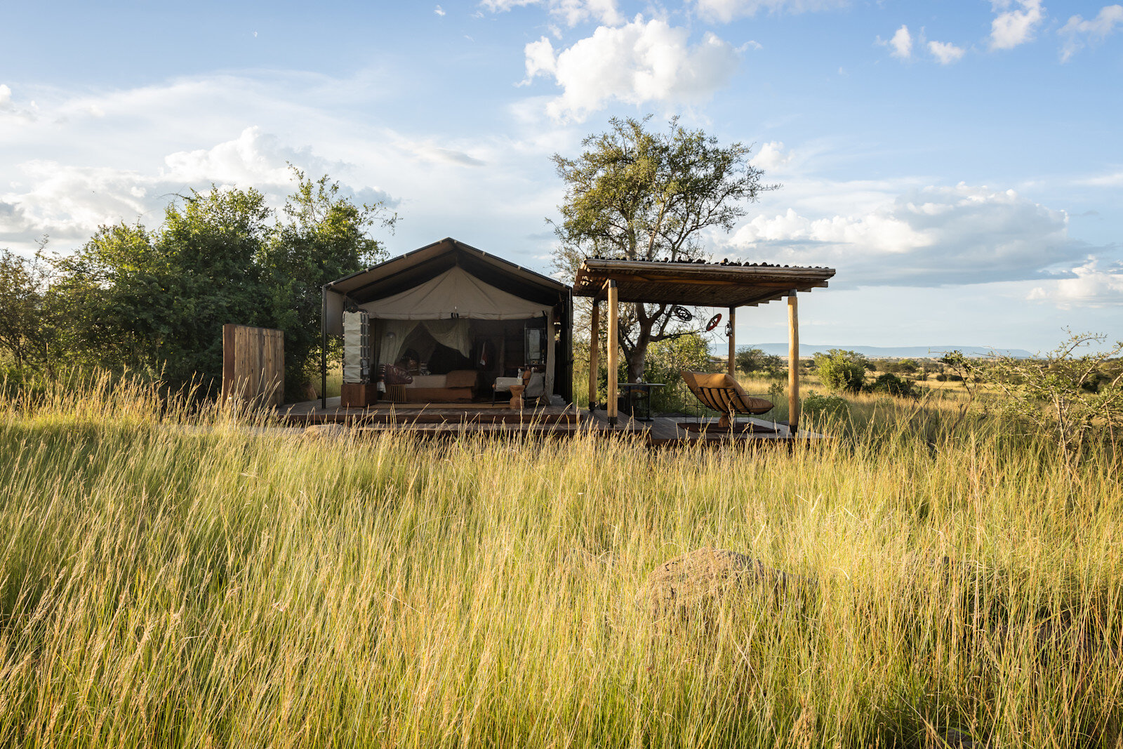Tented suite exterior at Singita Mara River Tented Camp set in the riverine grassland