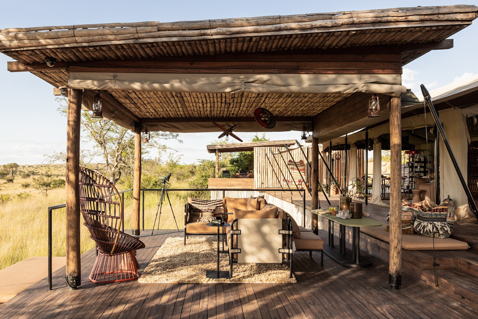 Front deck lounge at Singita Mara River Tented Camp with a hanging chair and river views
