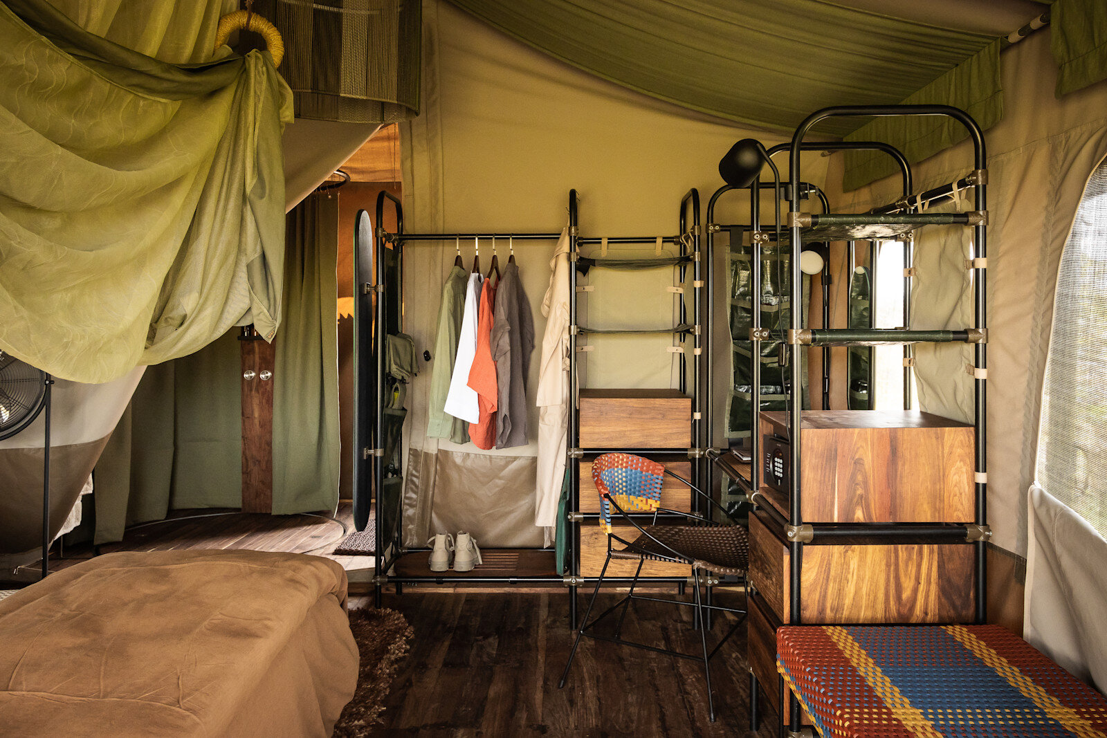 Suite interior at Singita Mara River Tented Camp with a canopy bed and open dressing area