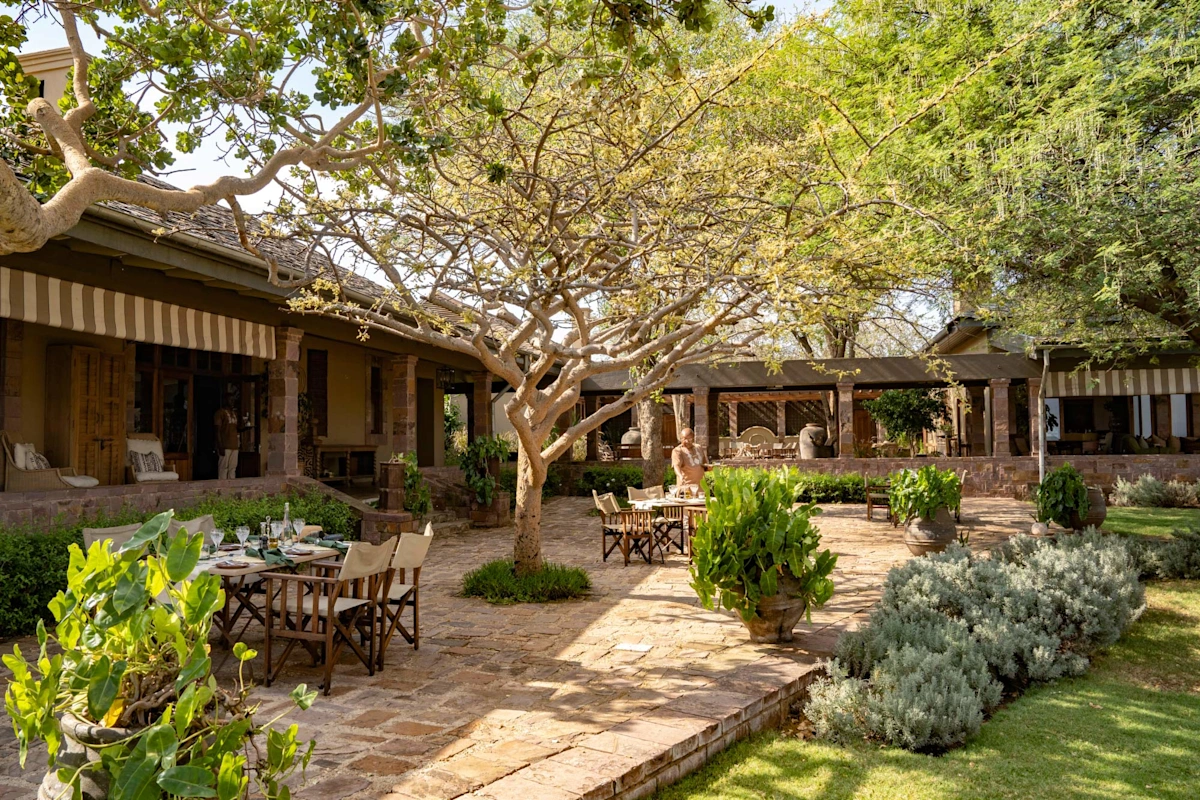 Singita Sasakwa Lodge Edwardian-style manor house on Sasakwa Hill overlooking the Serengeti plains at golden hour in the Grumeti Reserve, Tanzania