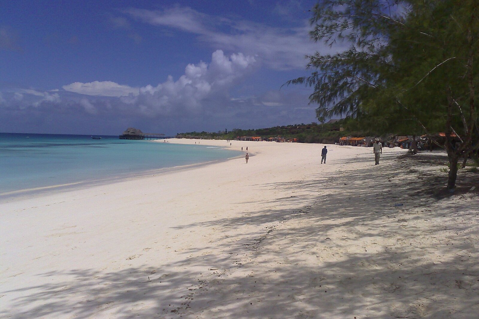 A long empty white-sand beach fronting a Zanzibar resort